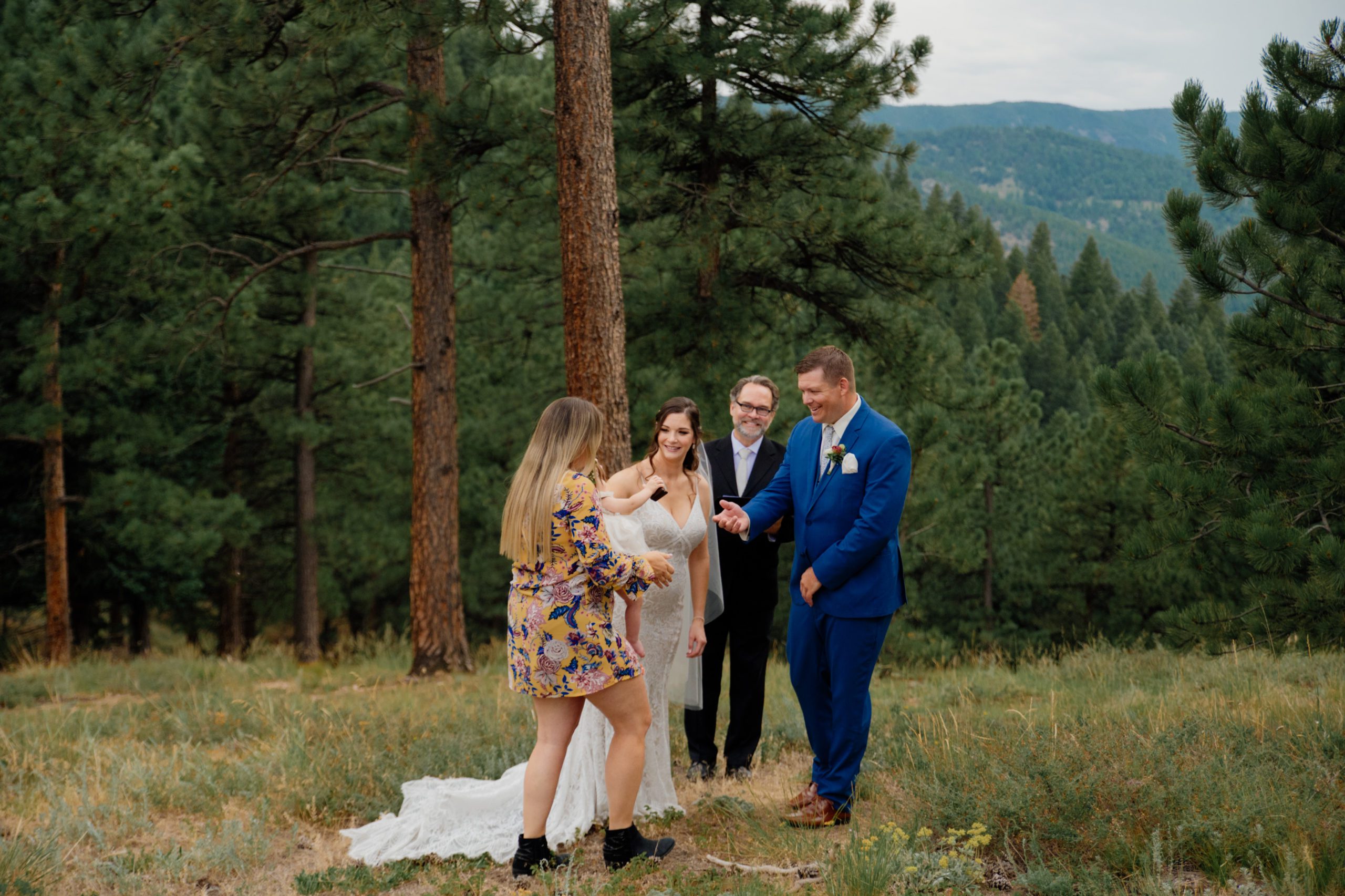 The friend of the couple brings their baby to give them their rings after the ring-warming ceremony during their elopement at artist point 