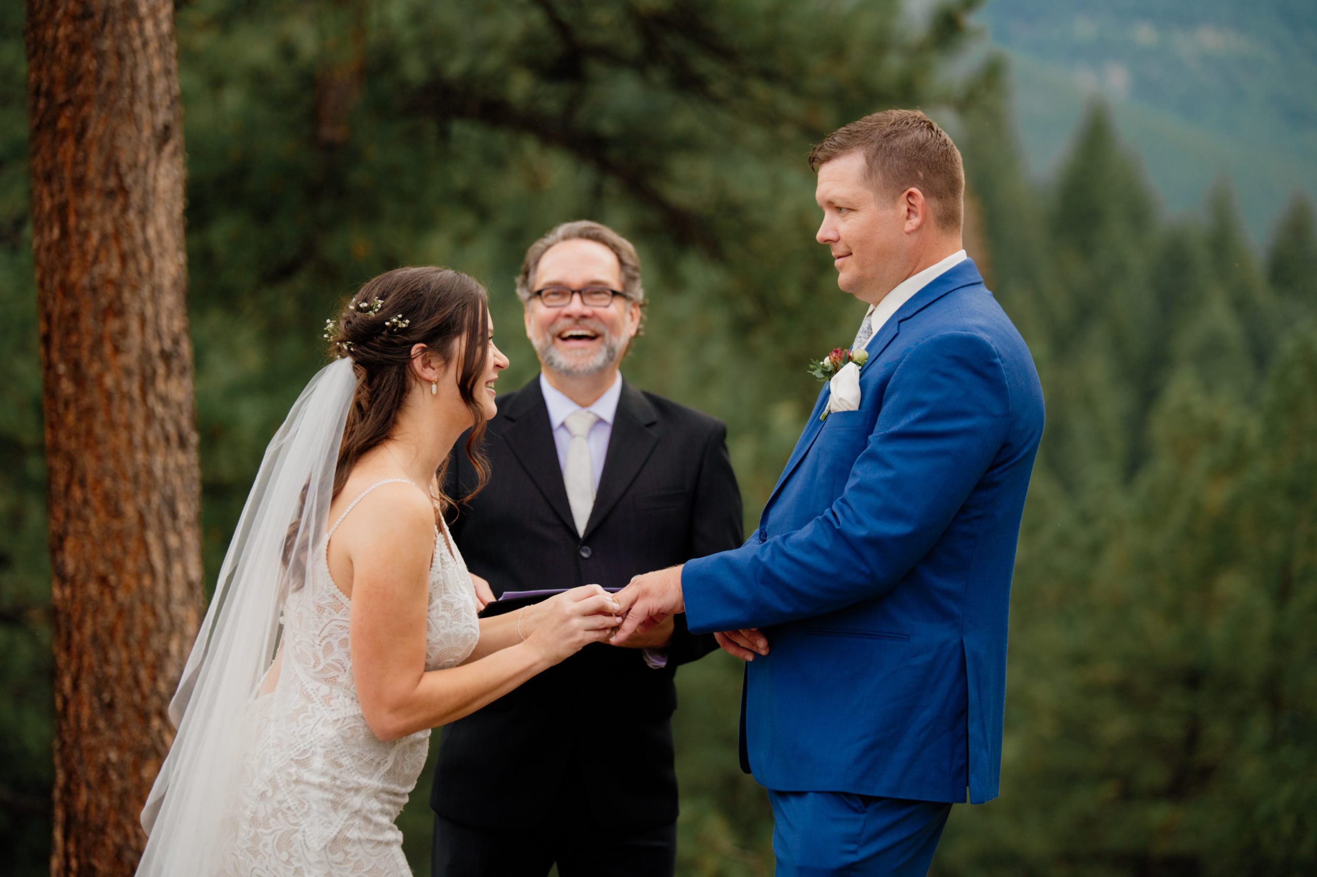 The bride places a ring on her grooms hand during their artist point elopement ceremony.