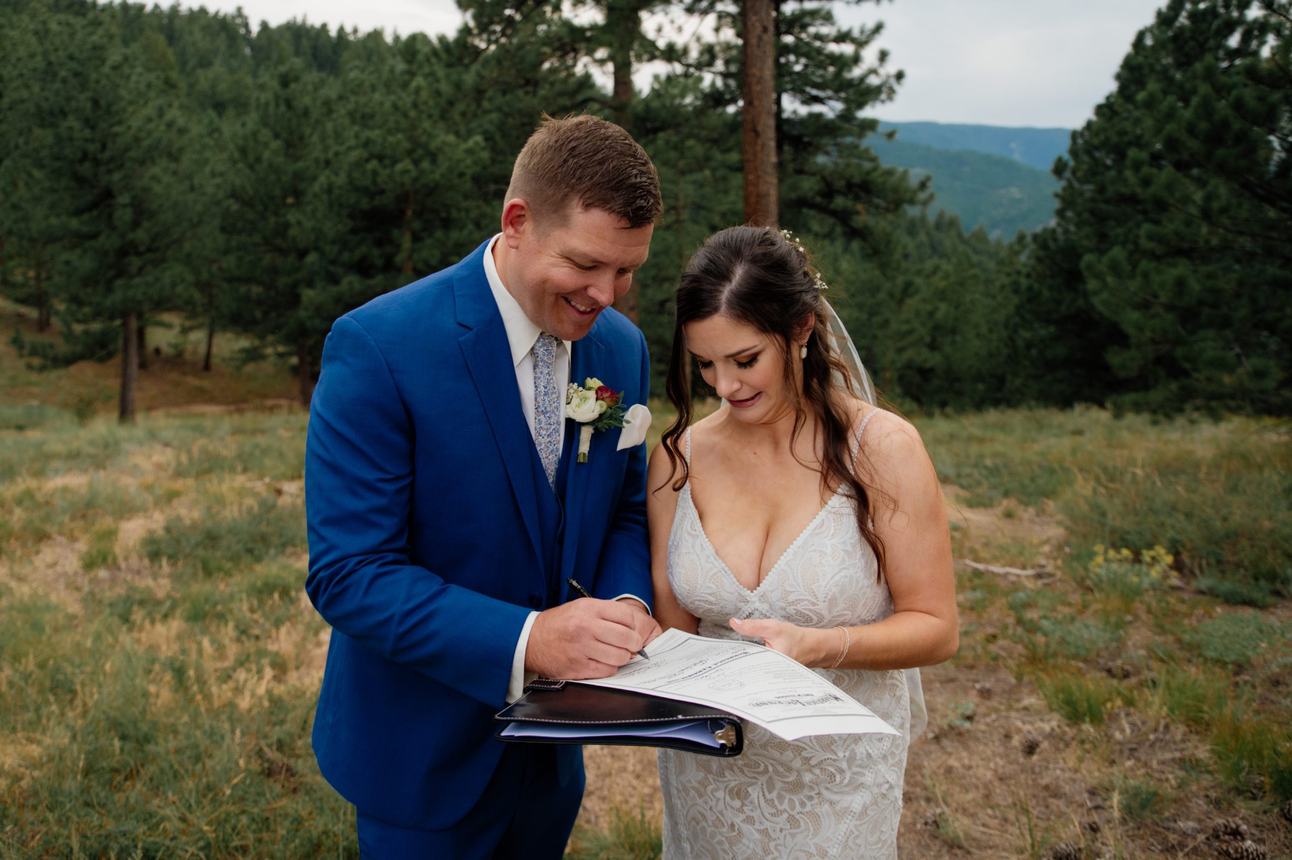 The bride and groom signing their marriage license after their artist point elopement 