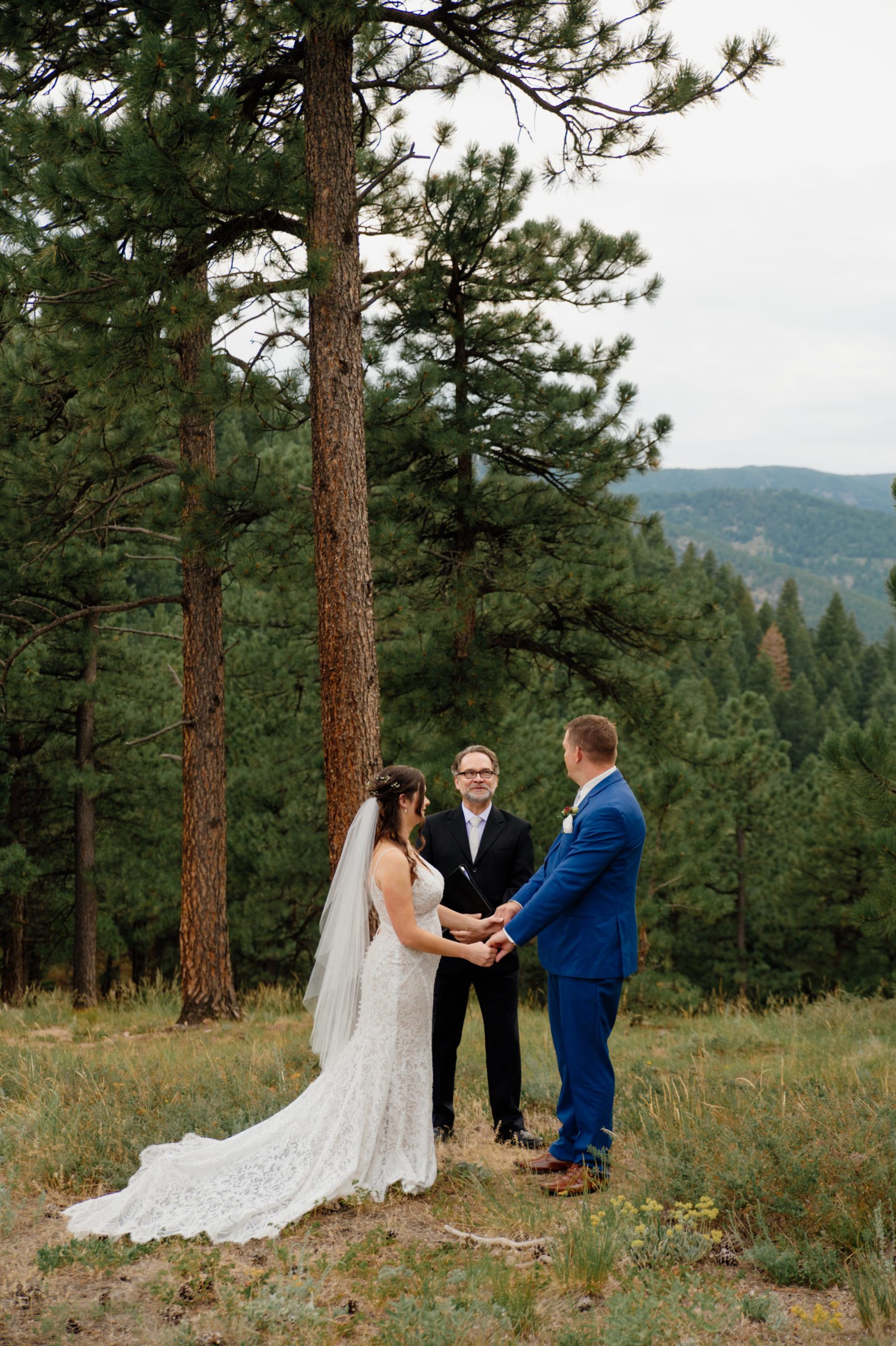 The bride and groom hold hands at the start of their ceremony at their artist point elopement. 