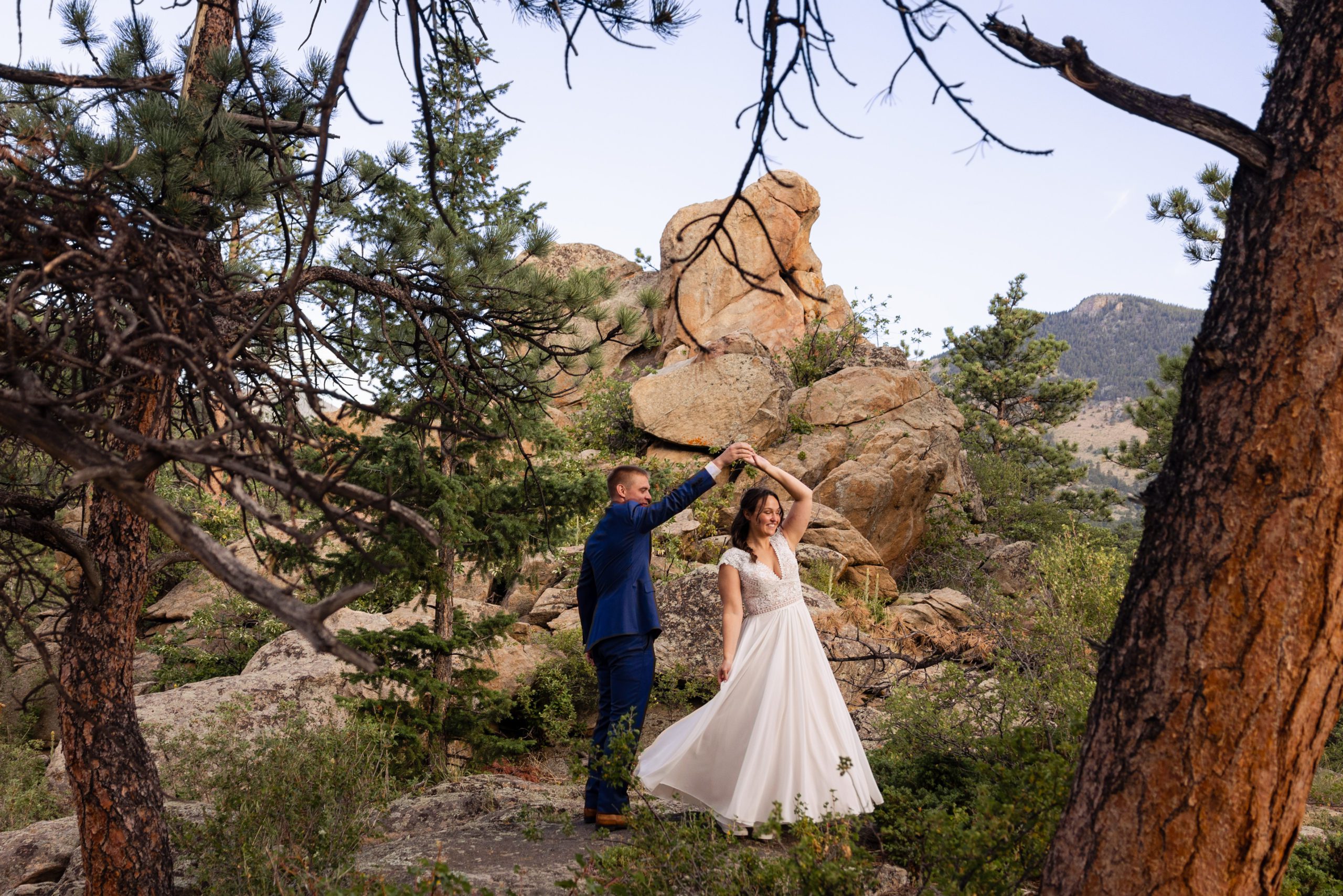 The groom and bride dancing in the woods, before their wedding at Romantic RiverSong Inn in Estes Park. 