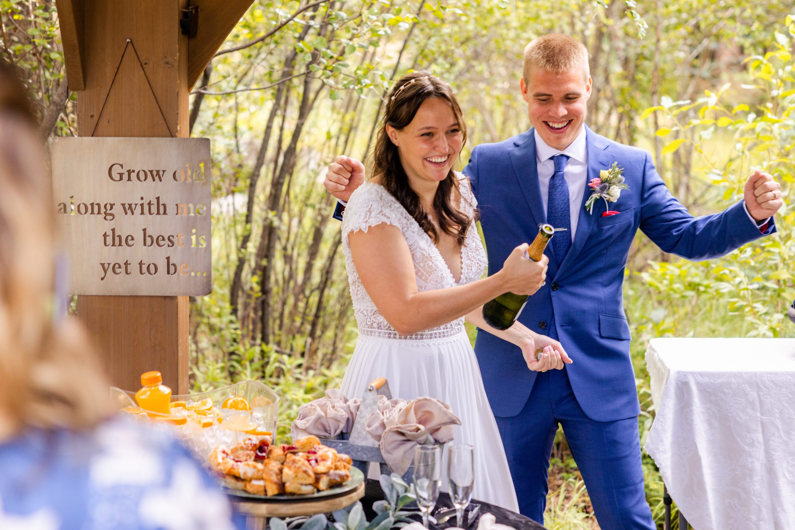 The bride pops a bottle of champagne at their reception at Romantic RiverSong Inn in Estes Park during their wedding. 