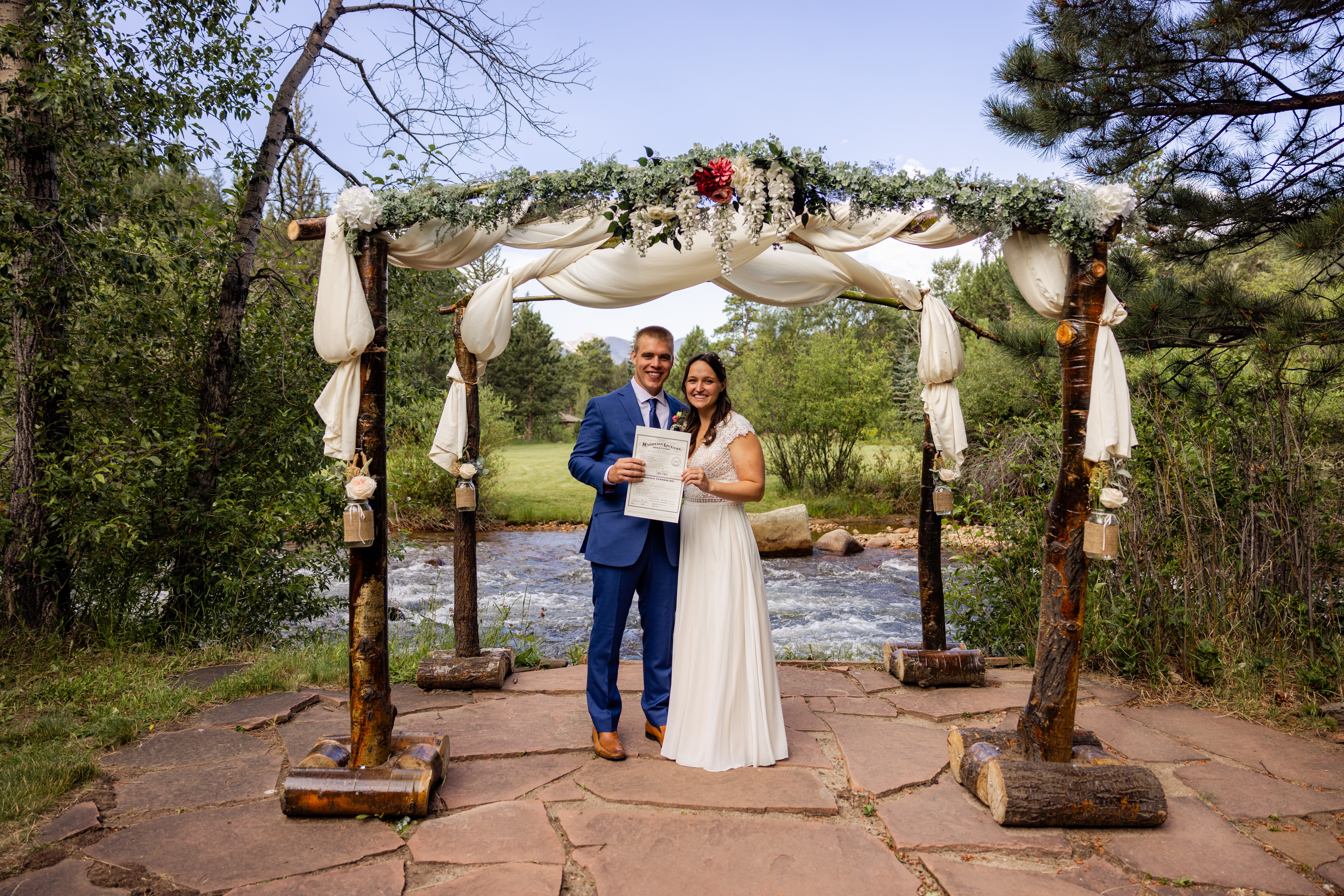 The bride and groom holding their marriage license at Romantic RiverSong Inn in Estes Park. 
