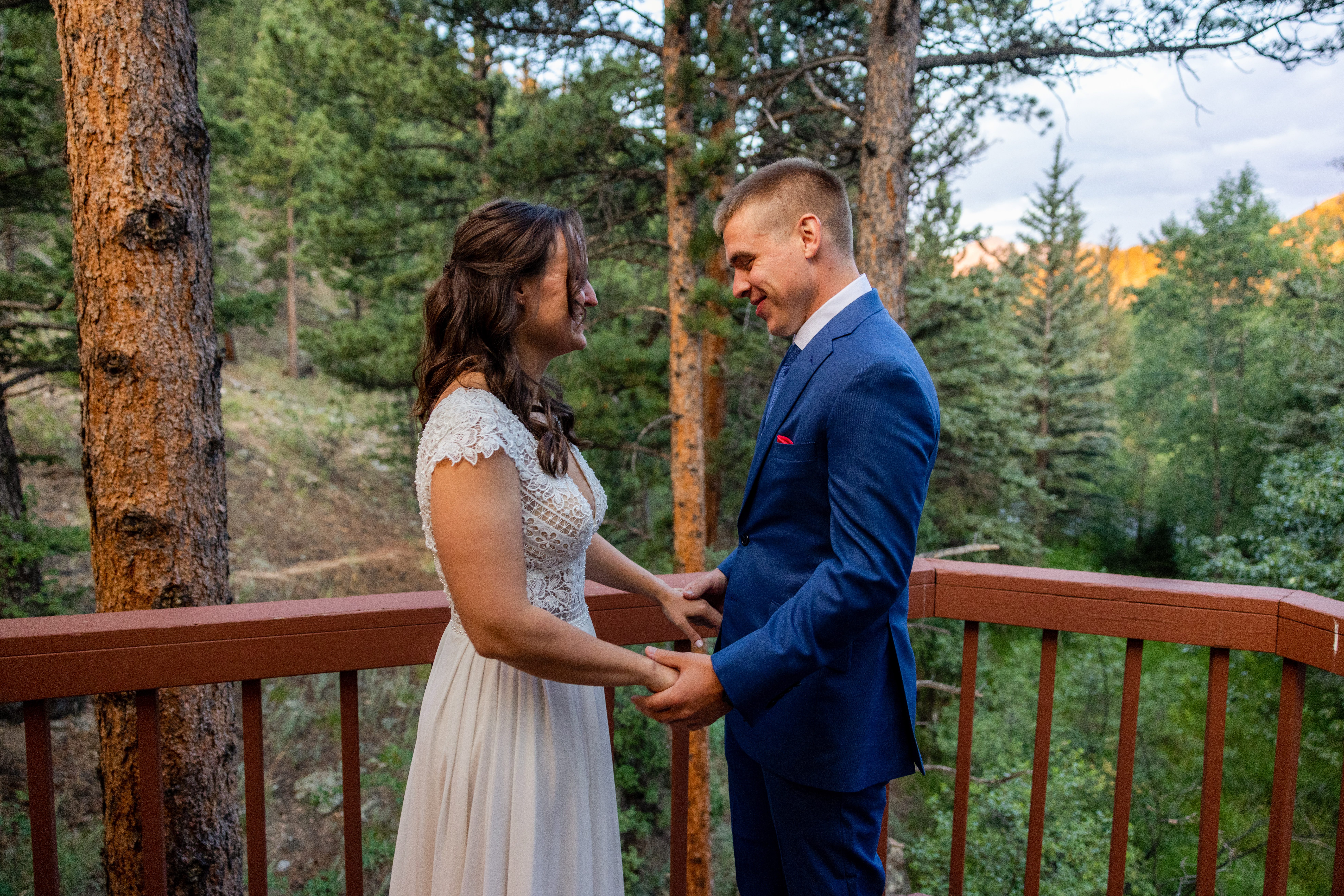 the groom looks at his brides dress after their first look at Romantic RiverSong Inn in Estes Park on their wedding day 