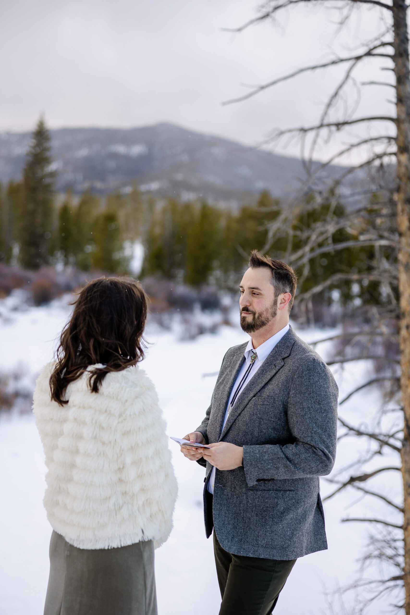 the groom looking at his bride, reading his vows, during their Winter Park elopement ceremony. 