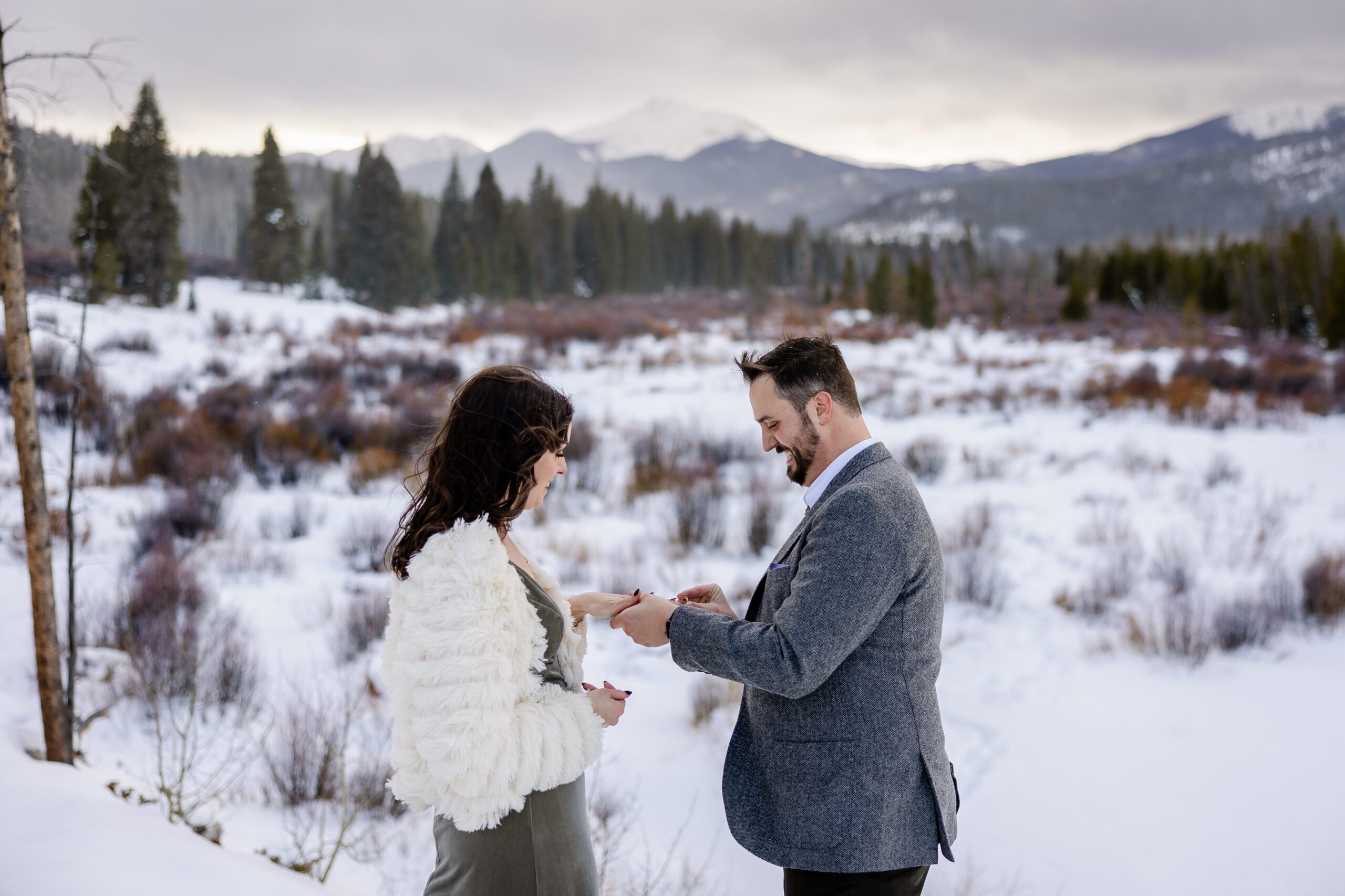 the groom putting the ring on his bride's finger during their Winter Park elopement ceremony. 