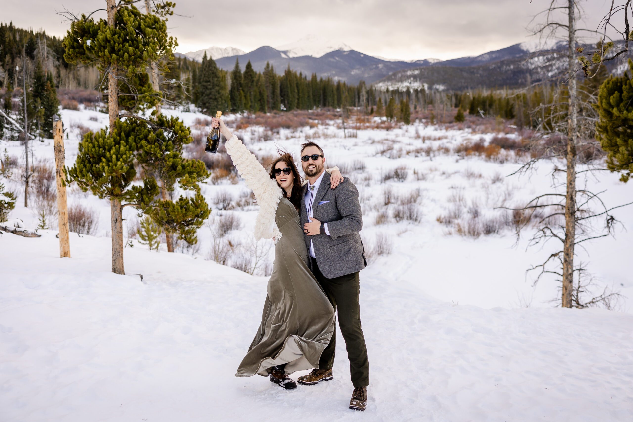 bride and groom wearing sunglasses celebrating with a bottle of champagne in hand at their Winter Park elopement.