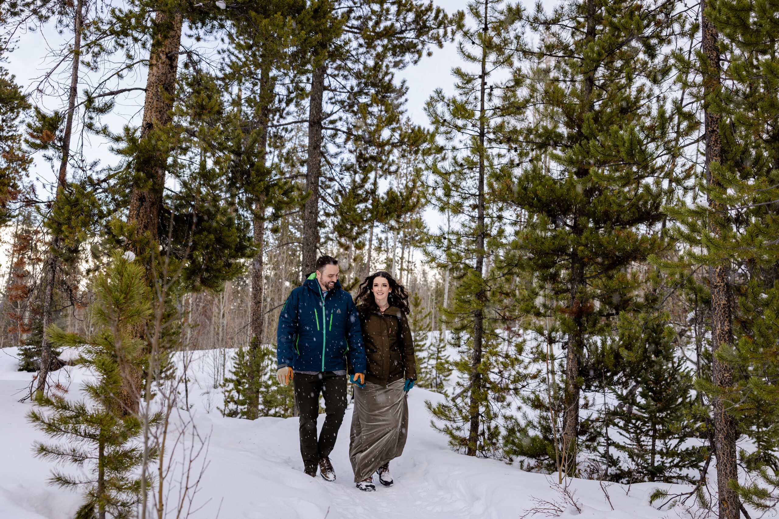bride and groom walking in the snow on their Winter Park elopement day. 