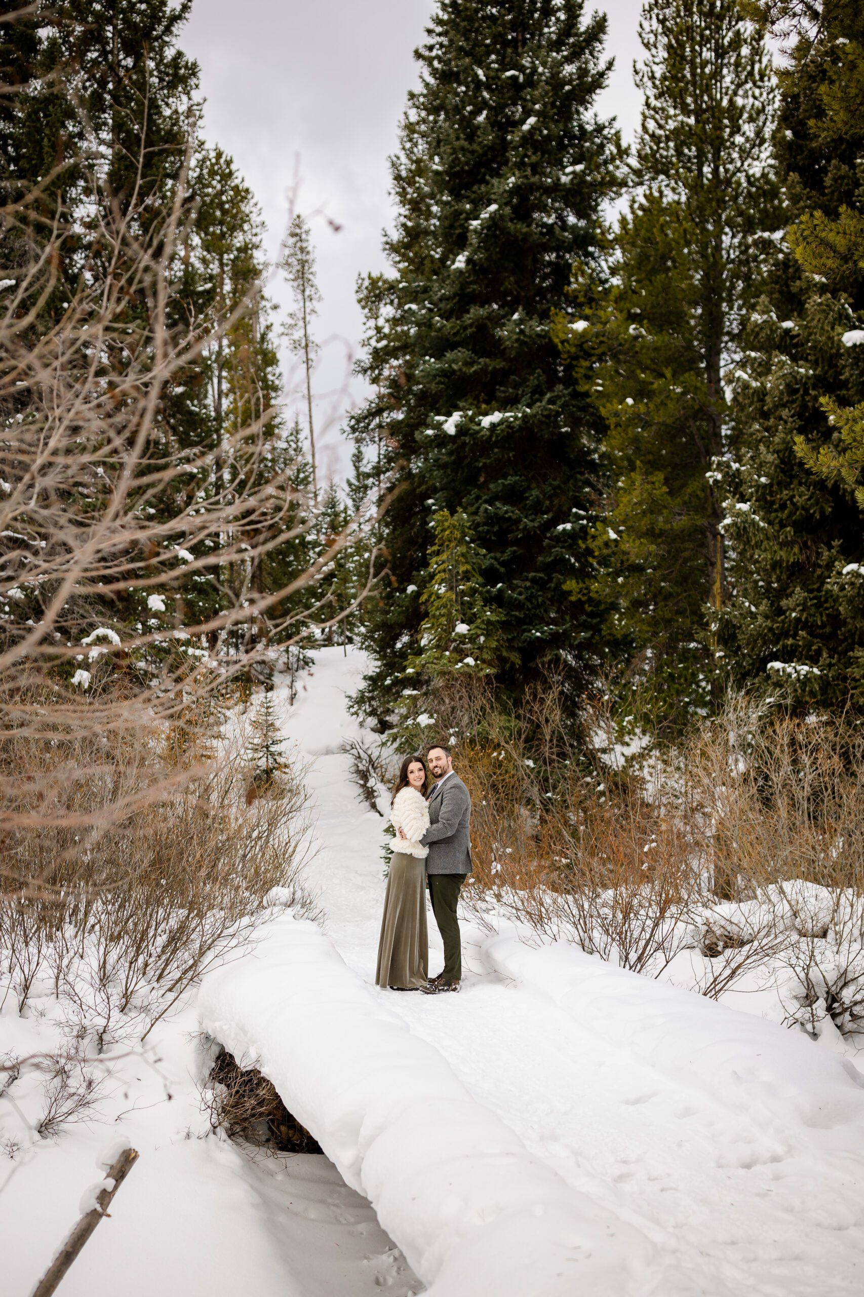 the beautiful bride dressed in head to toe in green and white jacket with her groom on their Winter Park elopement. 