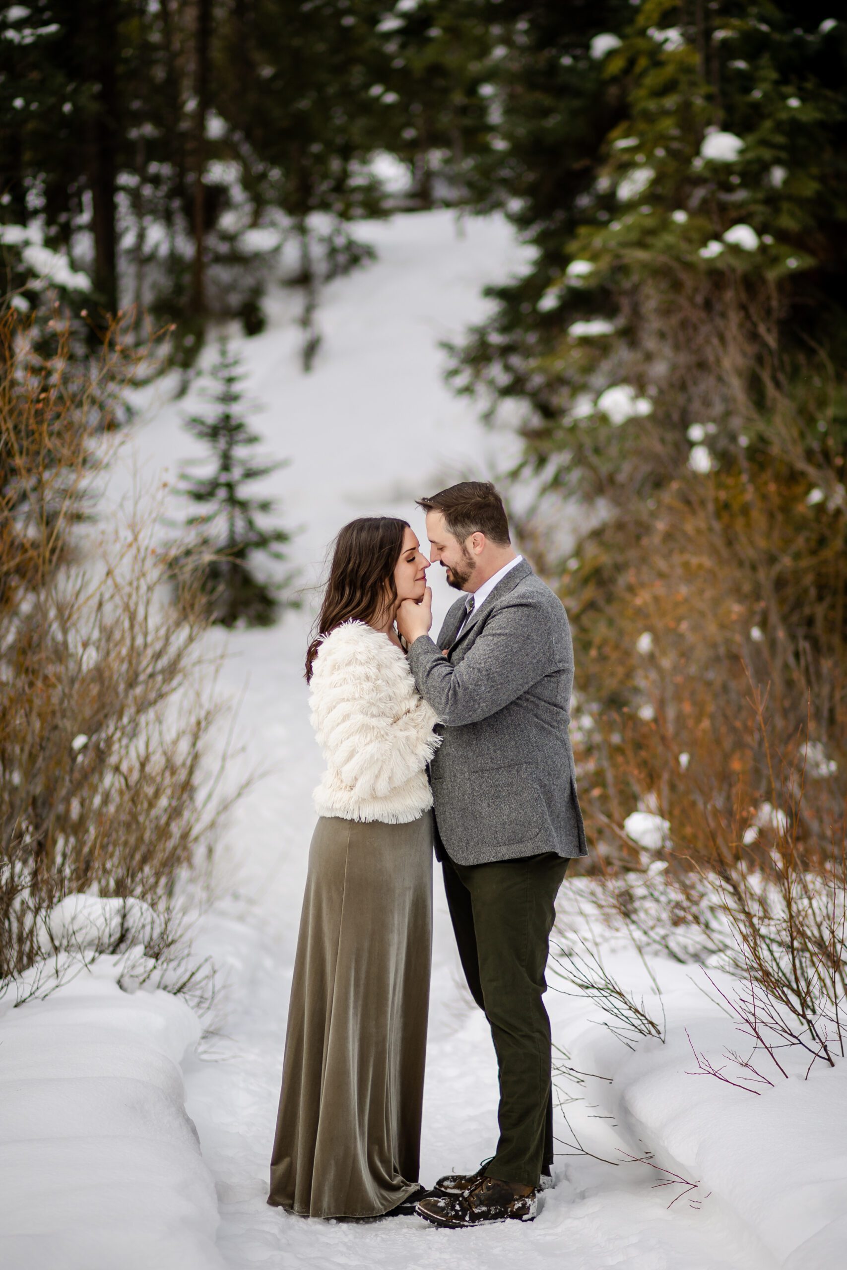 the groom holds his bride's face, both smiling during their Winter Park elopement.