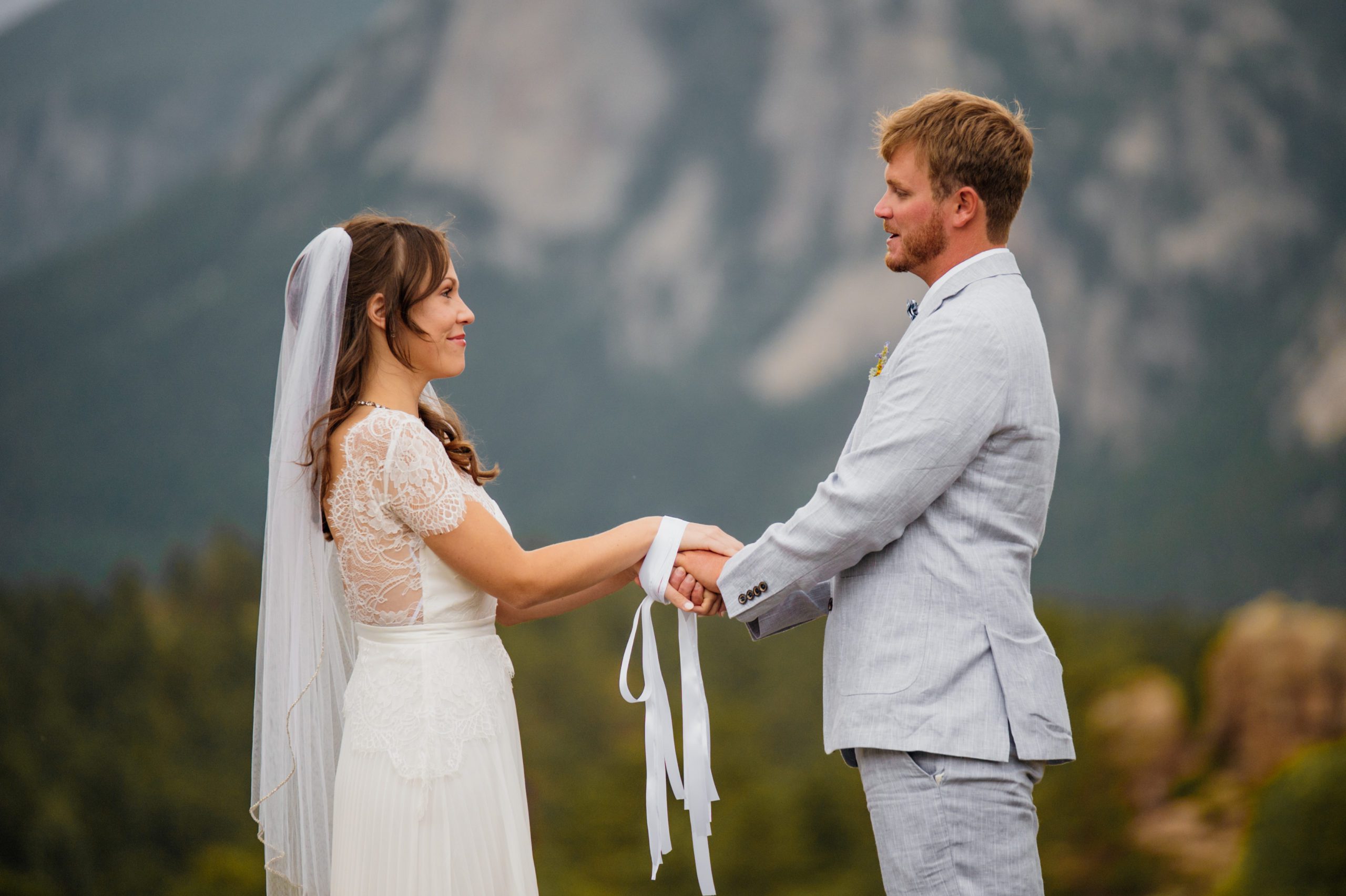 A close up shot of the bride and groom during their hand-fasting ceremony during their elopement at  Knoll Willows in Estes Park.