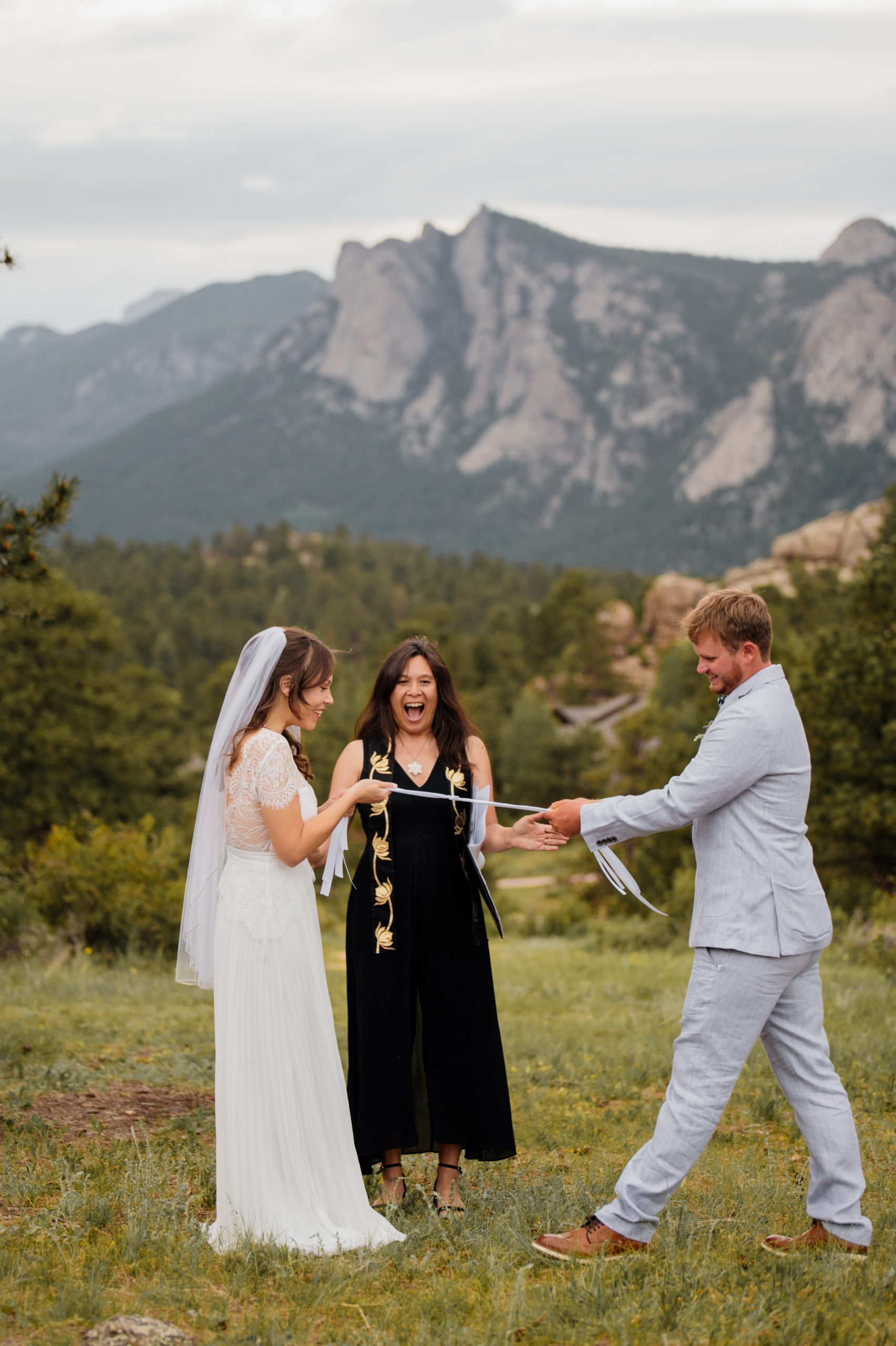 The couple pulls the rope  from their hand-fasting ceremony during their elopement ceremony at Knoll Willows in Estes Park.