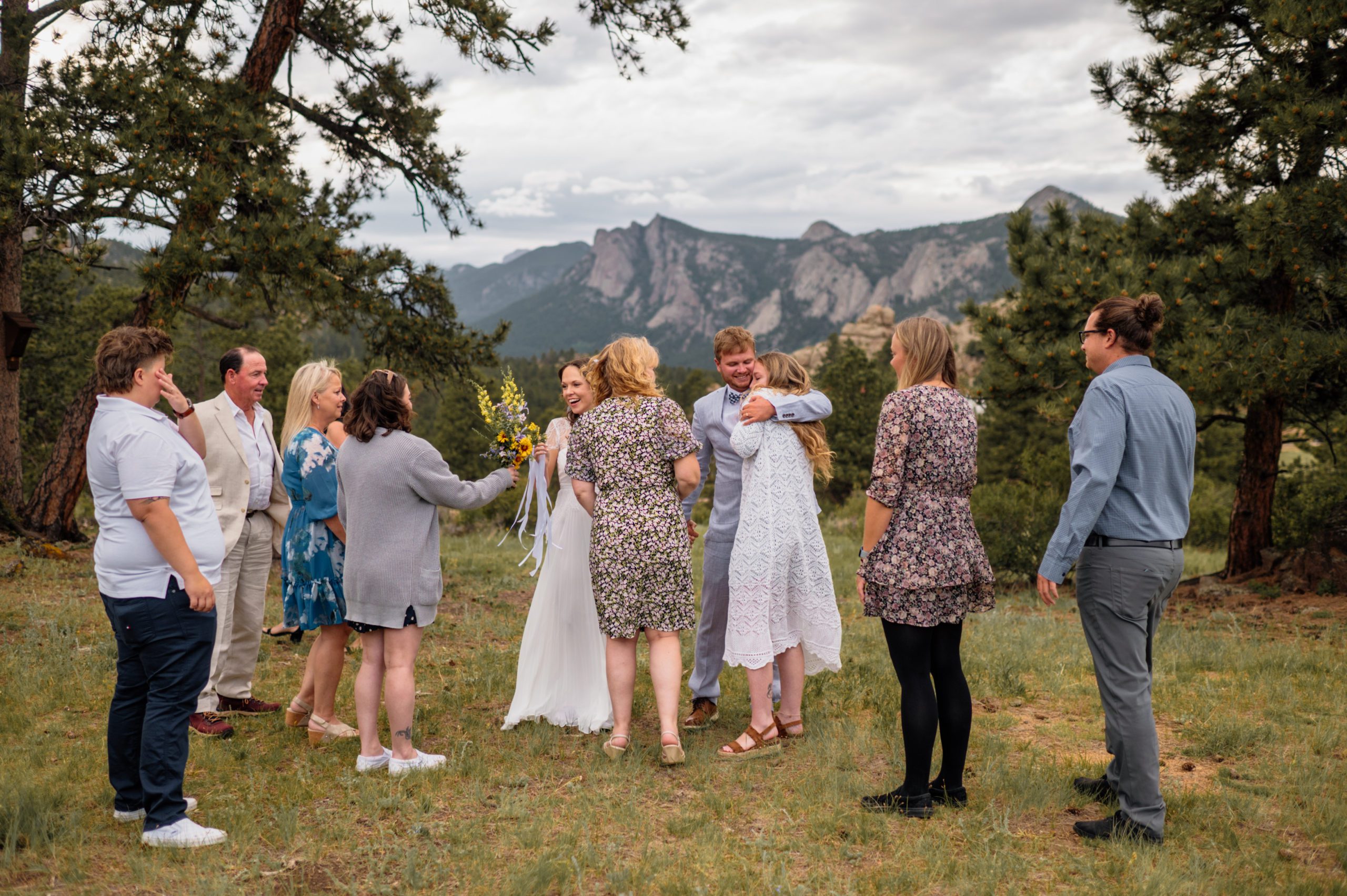 The bride and groom hugging their family during after their elopement ceremony at Knoll Willows in Estes Park.