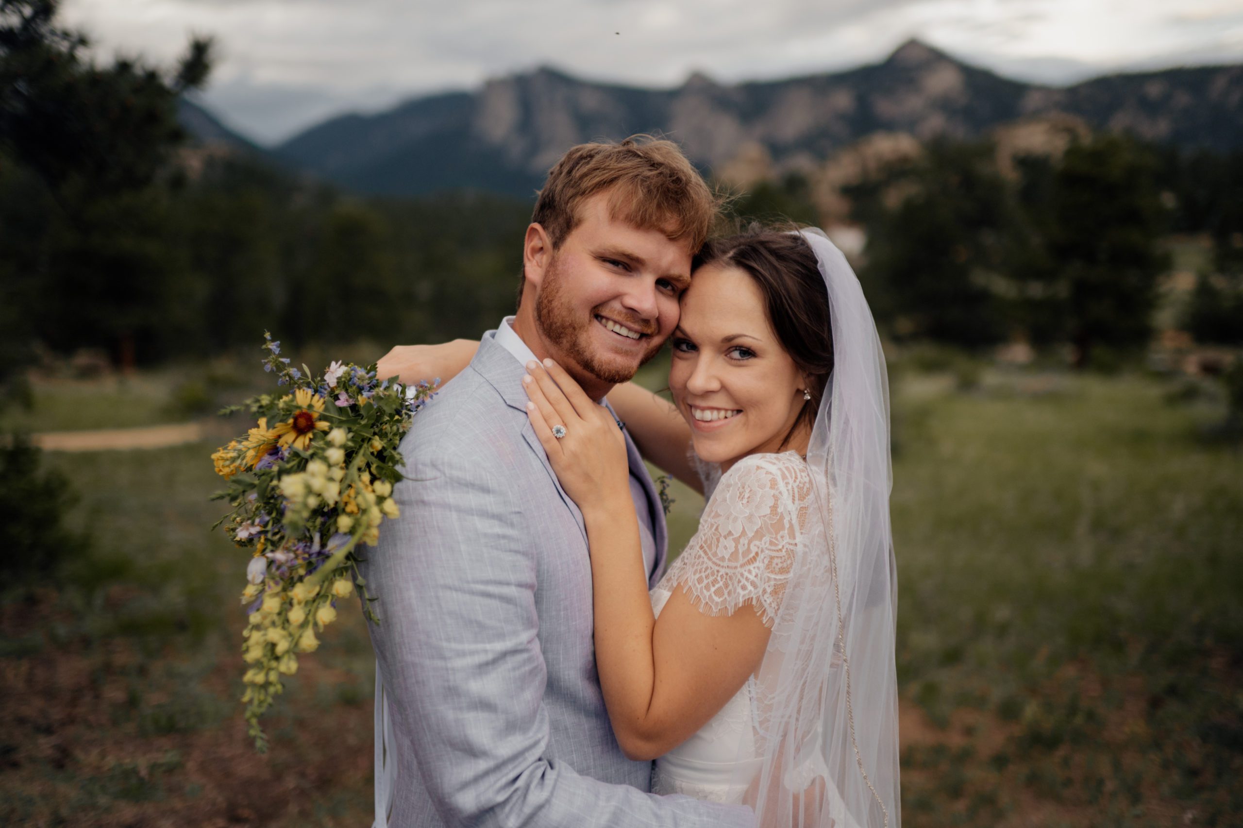 The bride and groom smile at the camera after their elopement at Knoll Willows in Estes Park. 