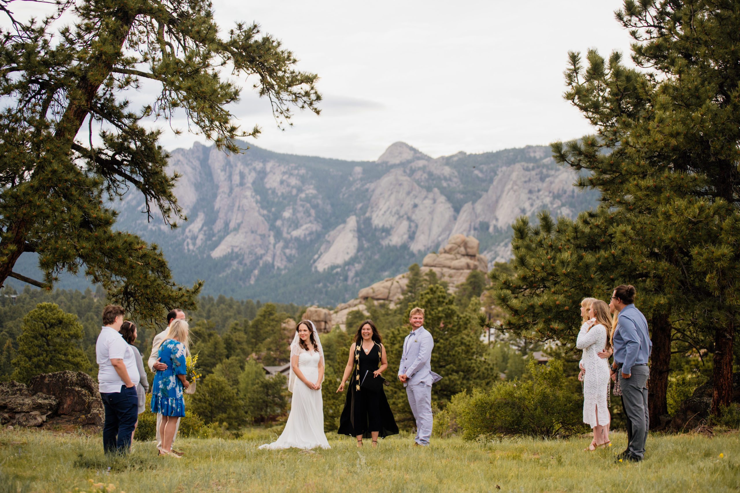 The bride and groom look back at their guests, soaking in the moment at their Knoll Willows elopement at Estes Park 