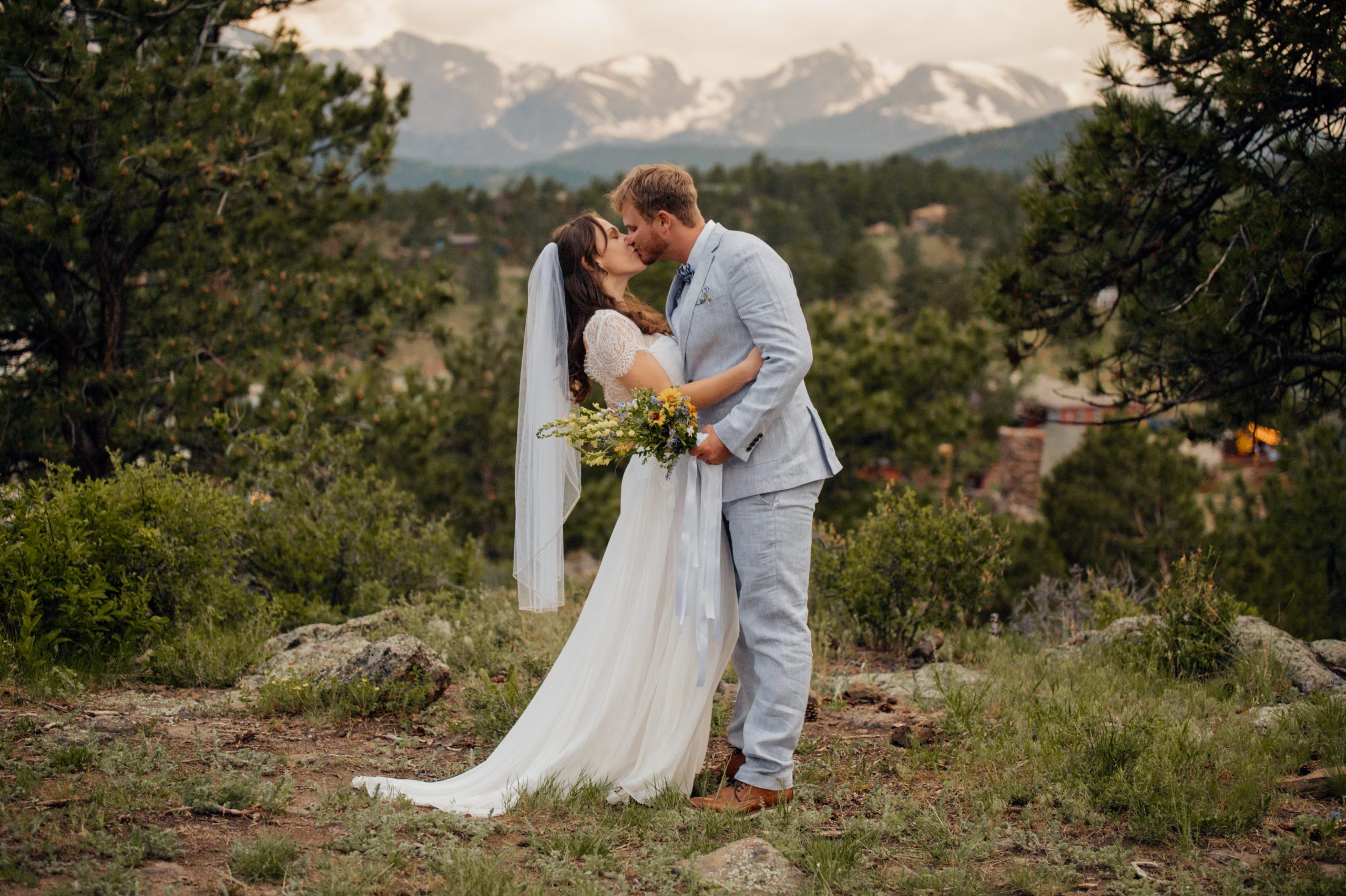 The bride and groom kiss after their elopement at Knoll Willows in Estes Park. 