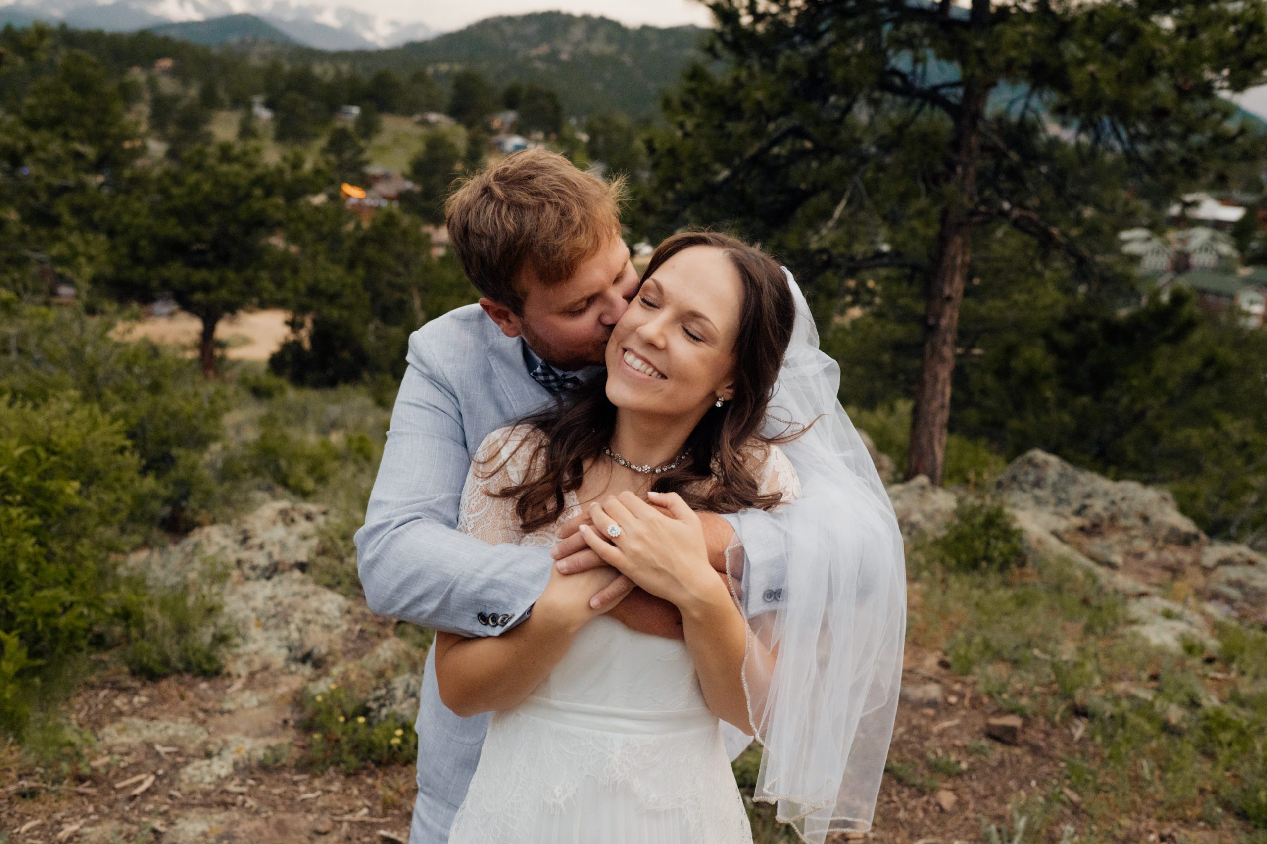 The bride kisses his bride with his arms wrapped around her. She smile sweetly after their elopement at Knoll Woods.