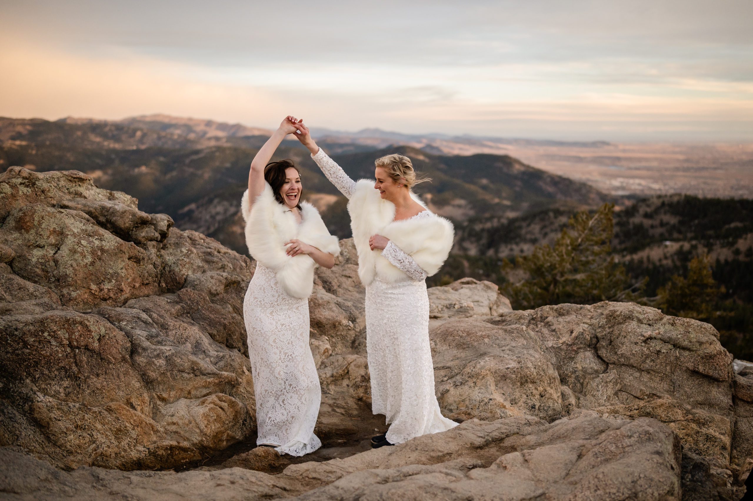 The bride's dancing together on top of the mountain at their Lost Gulch elopement ceremony. 