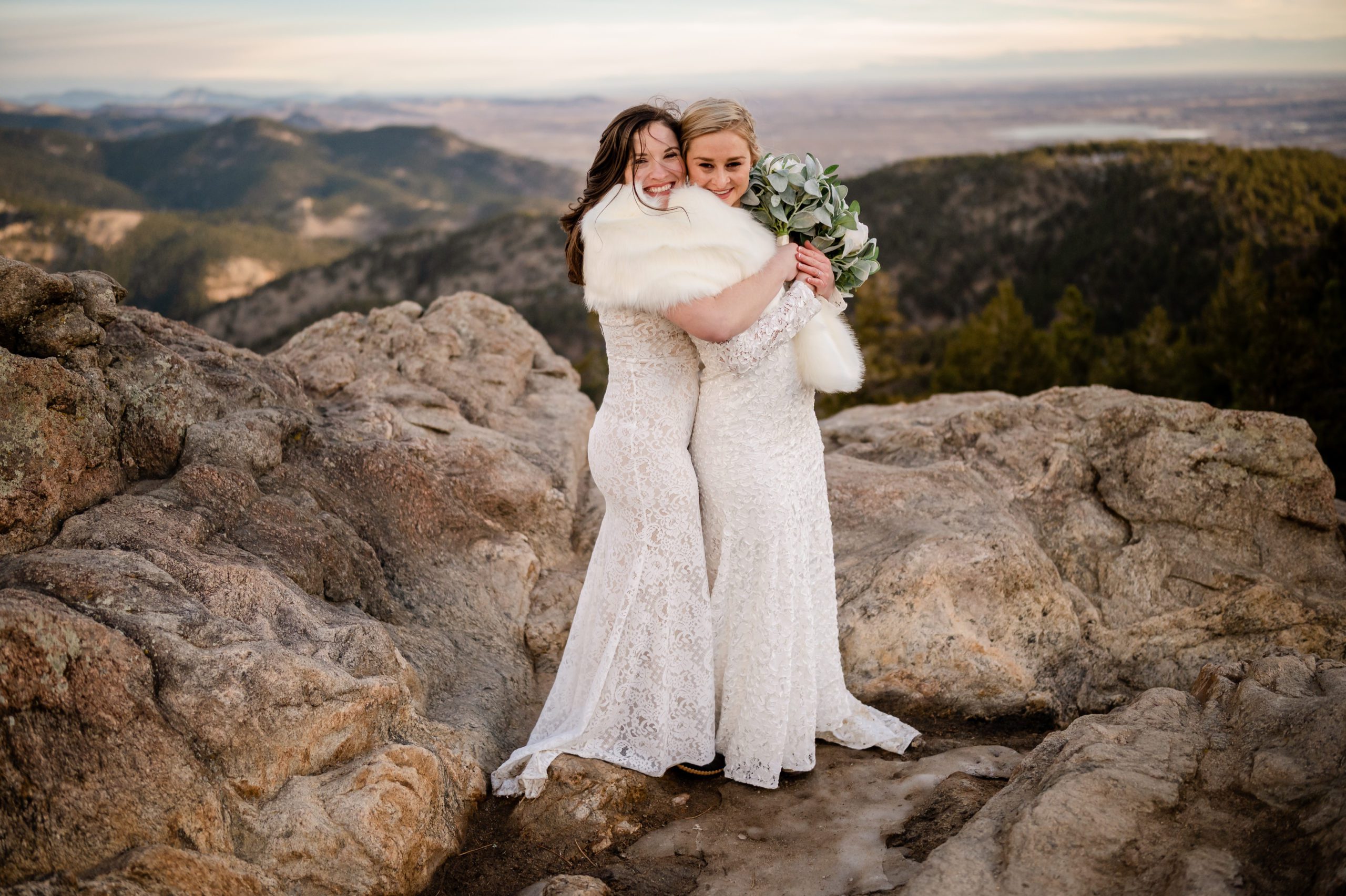 Both brides posing and being goofy with fur shawl at their Lost Gulch elopement. 
