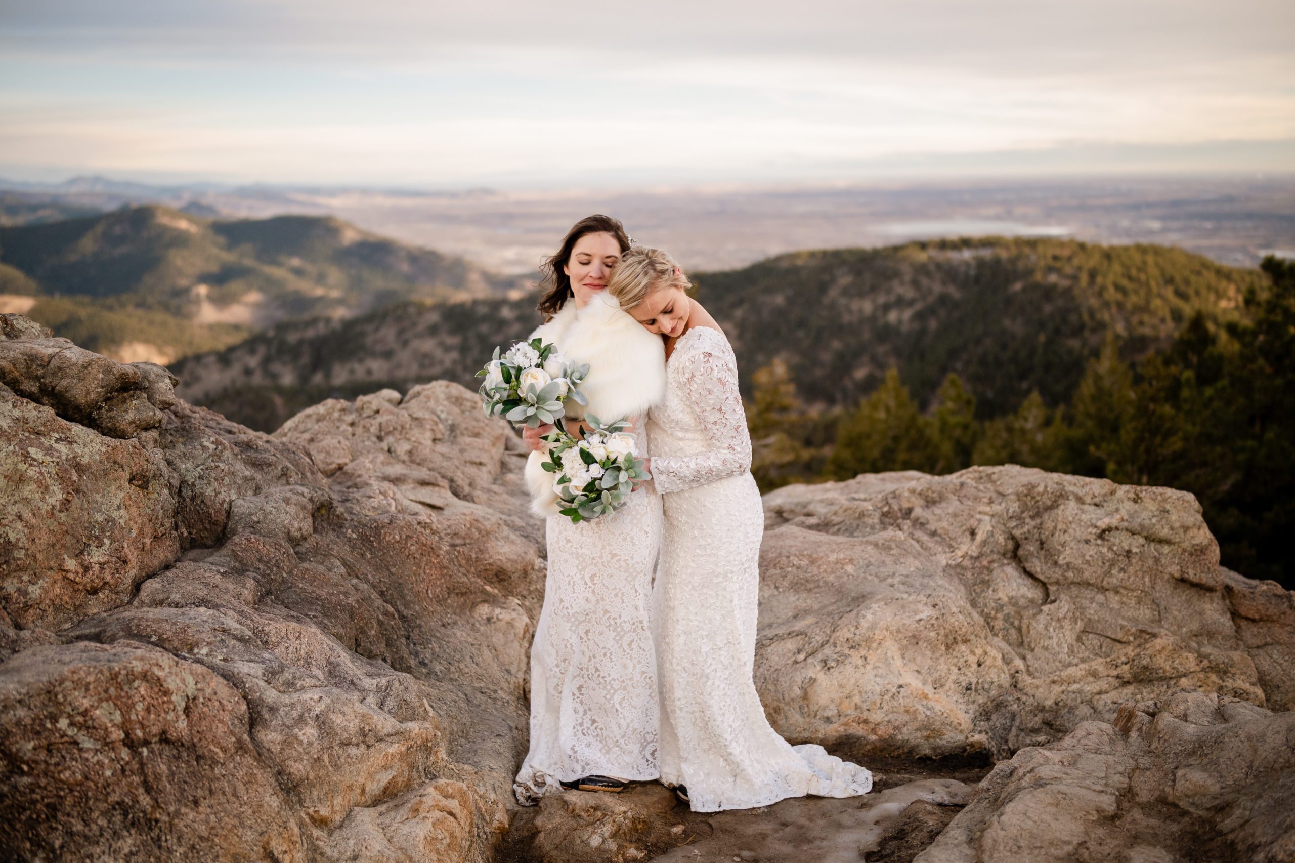 The bride puts her head on her wife's shoulder at their Lost Gulch Elopement. 