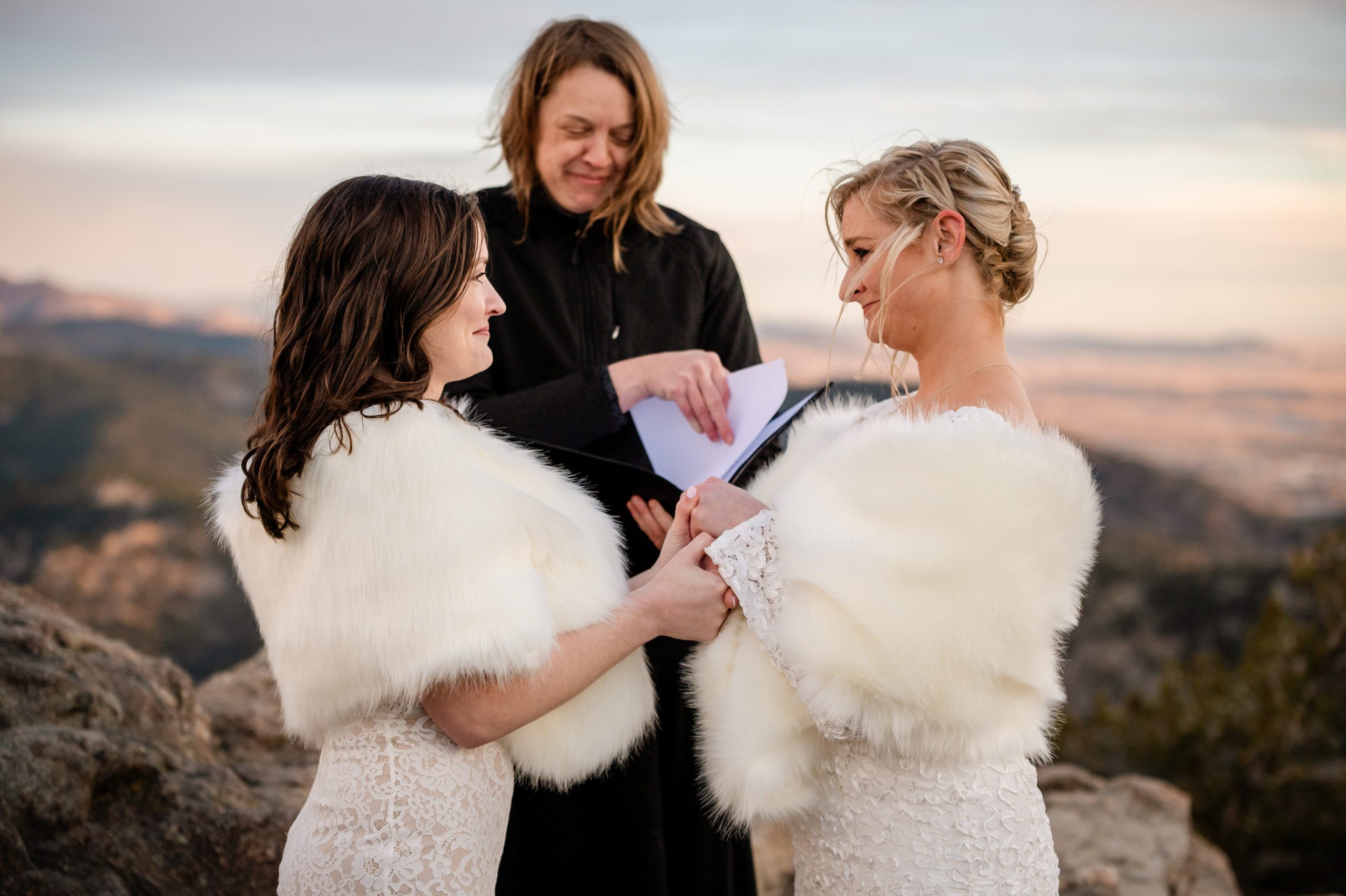 The two brides holding hands, and smiling sweetly at each other during their  Lost Gulch elopement  ceremony. 