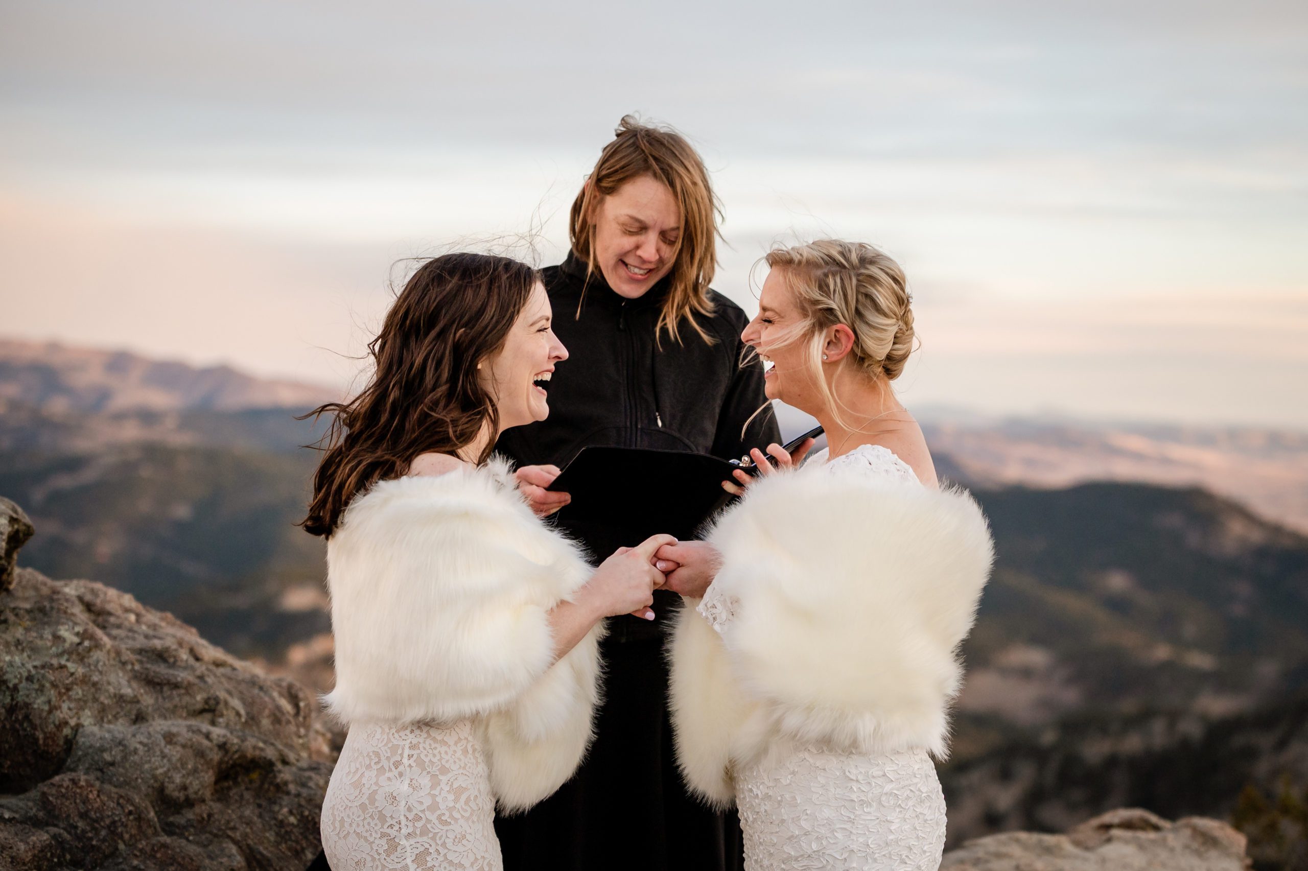 The brides laughing with each other during their Lost Gulch elopement ceremony. 
