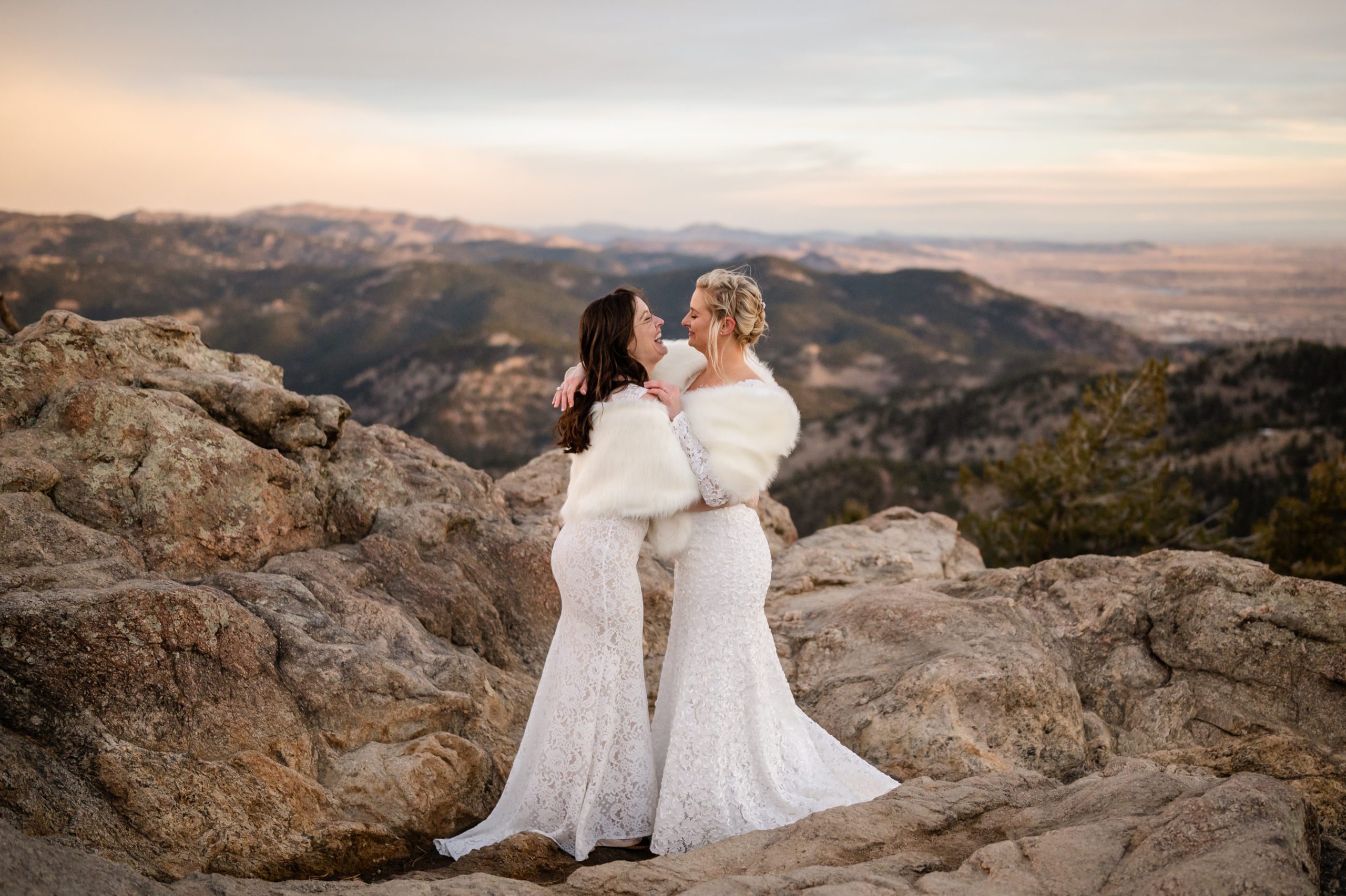 The brides smiling and laughing together during their Lost Gulch elopement ceremony. 