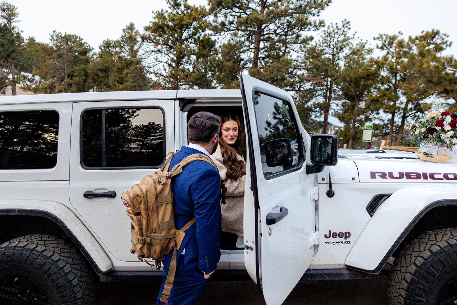 Groom opens the jeep door for his bride at their Lost Gulch elopement with  videography.