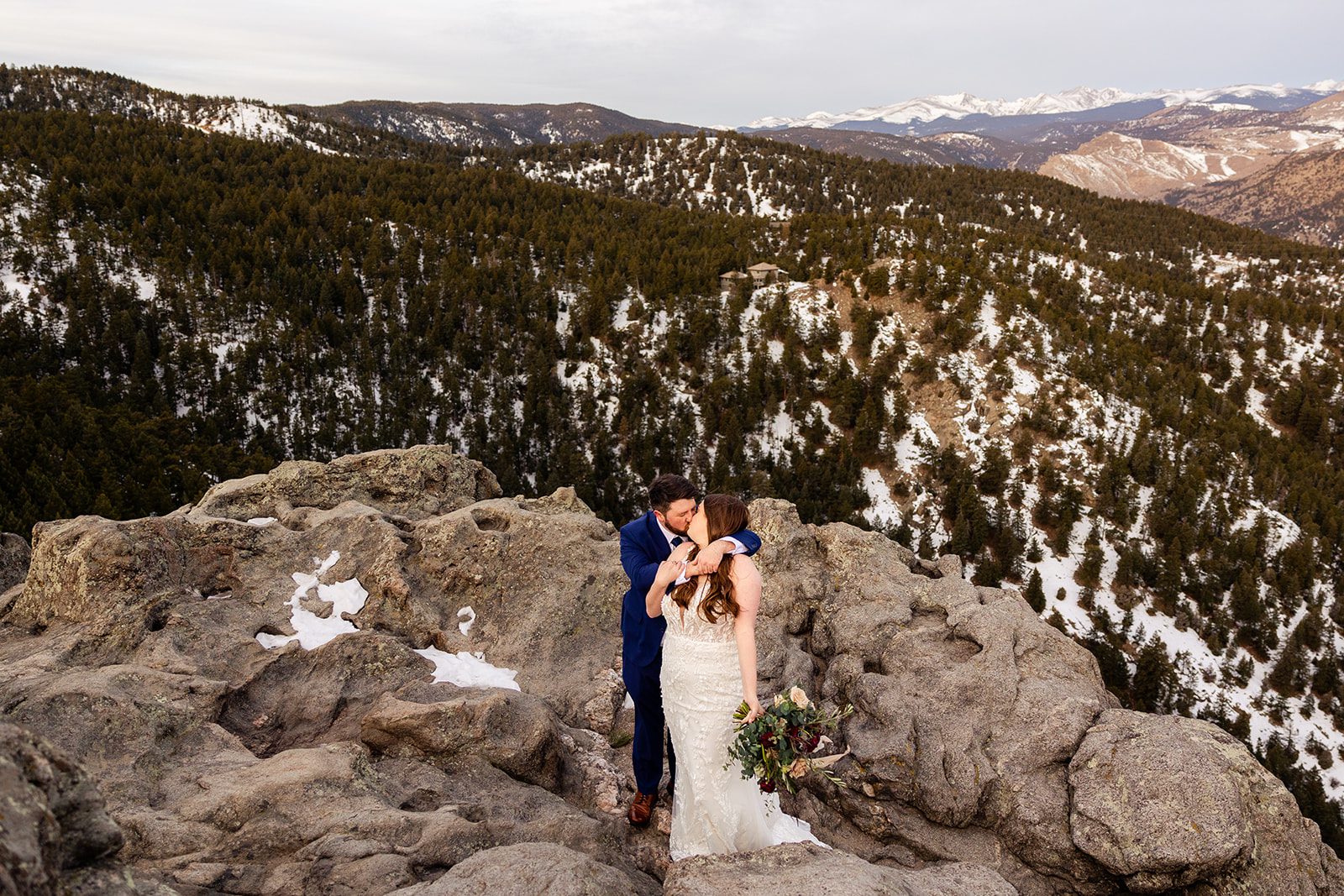 The bride leans back to kiss her groom during their Lost Gulch elopement with  videography.