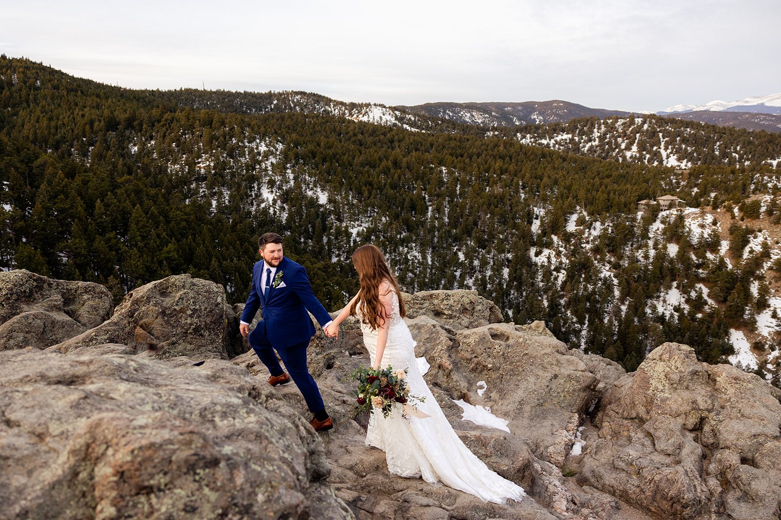 Groom holding his bride's hand during their Lost Gulch elopement with  videography.