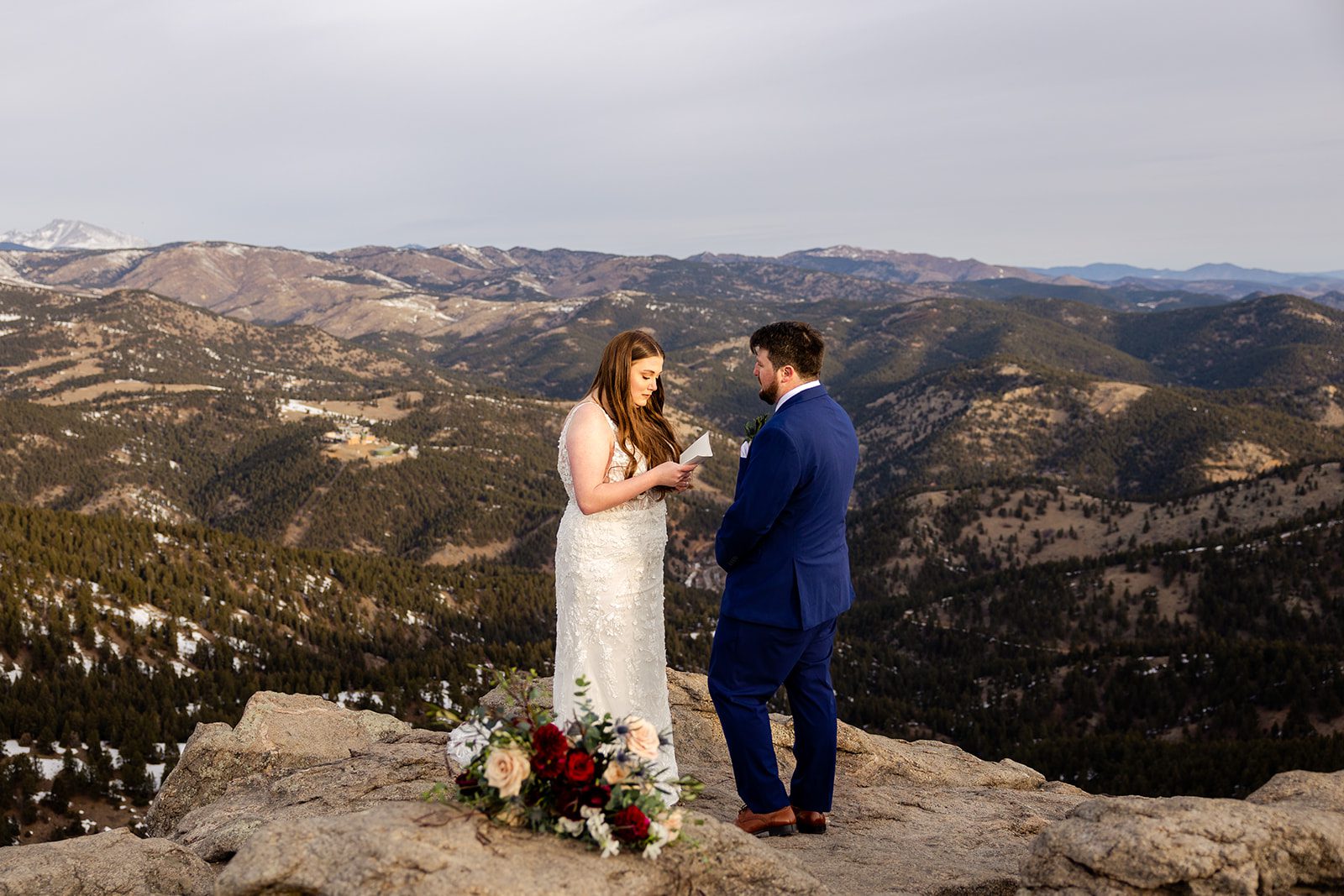 groom listening to bride while she shares her vows during their Lost Gulch elopement with  videography.