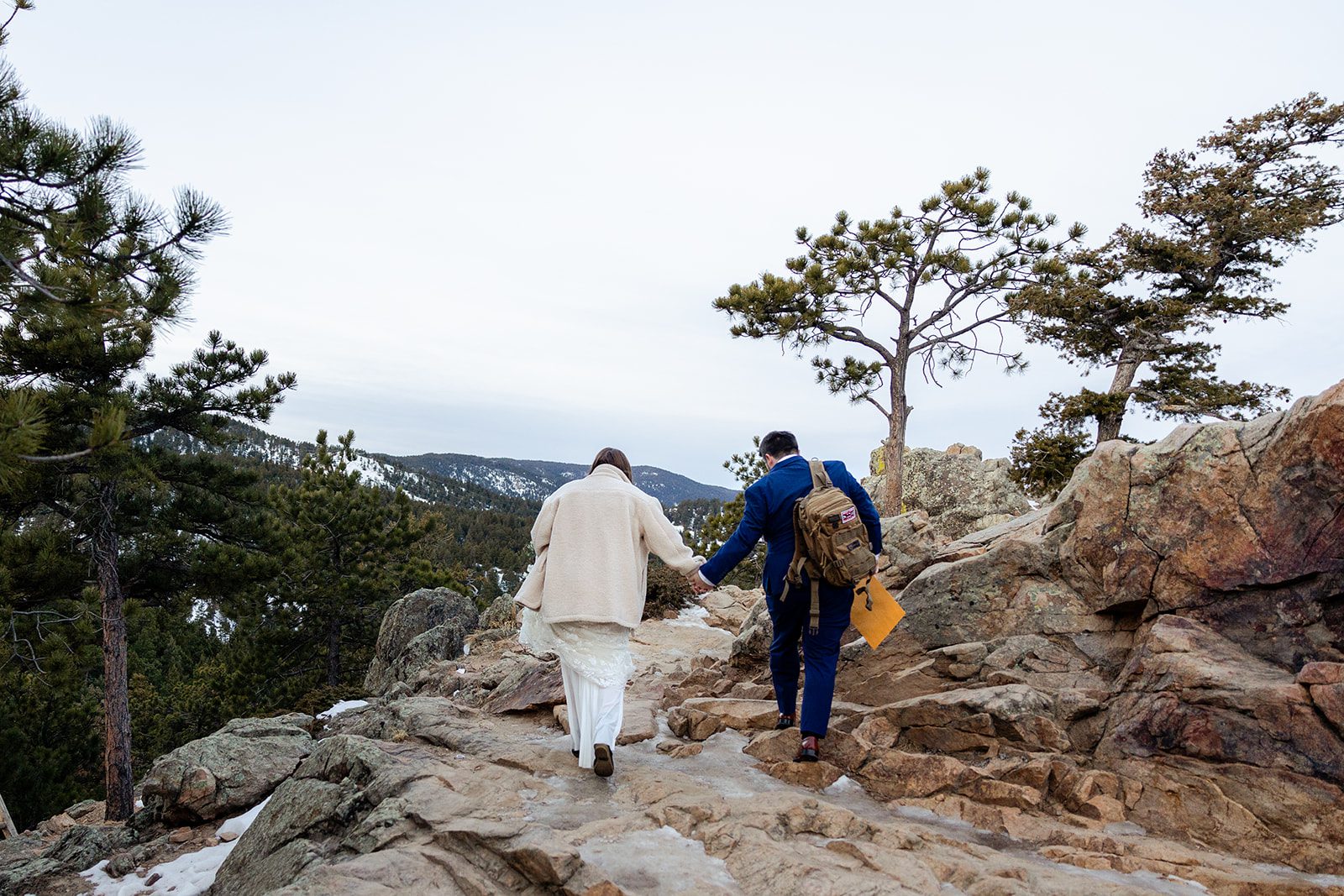 bride and groom walking hand in hand towards that ceremony location for their Lost Gulch elopement with  videography.