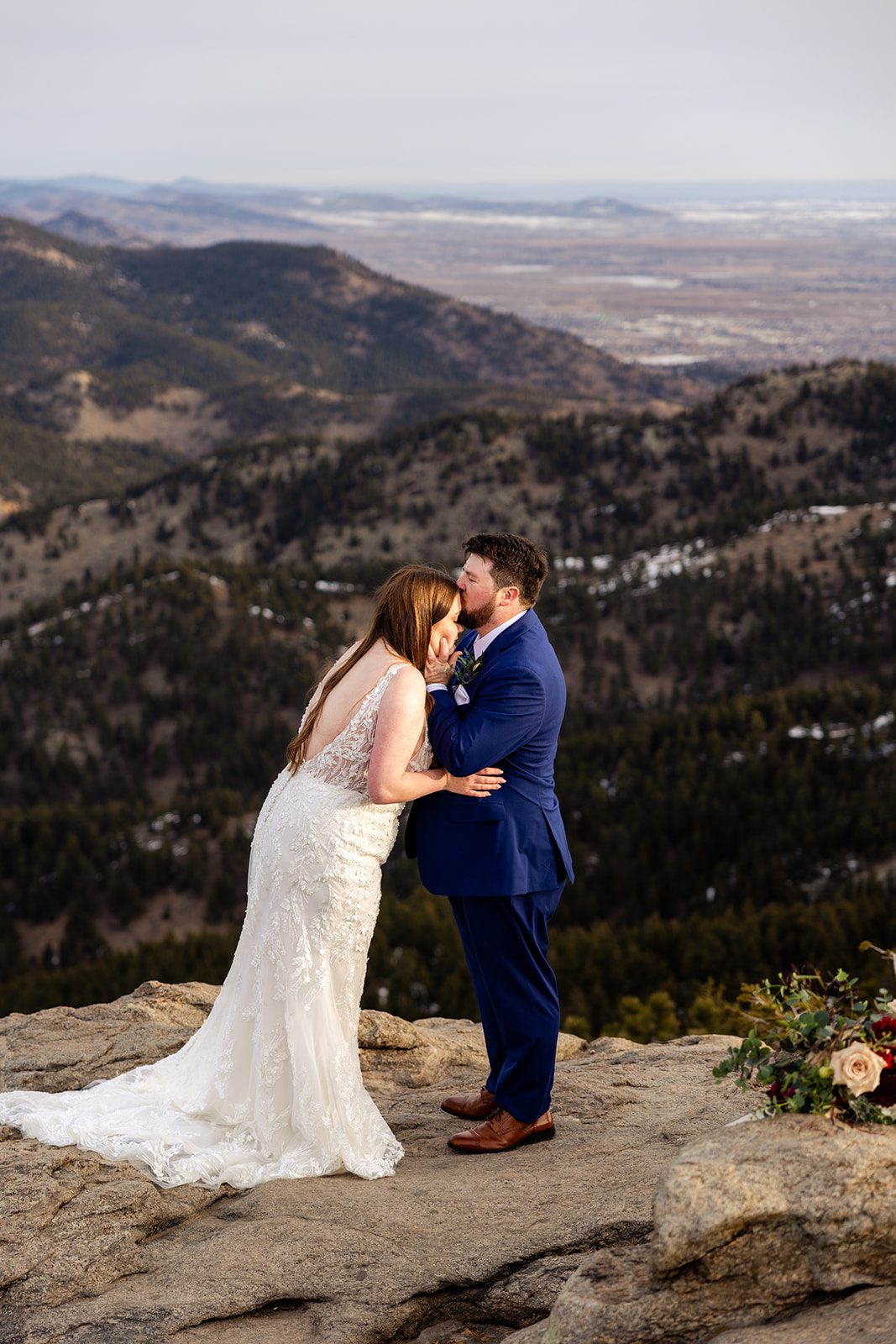 Groom kisses bride on the forehead after their Lost Gulch elopement with  videography.