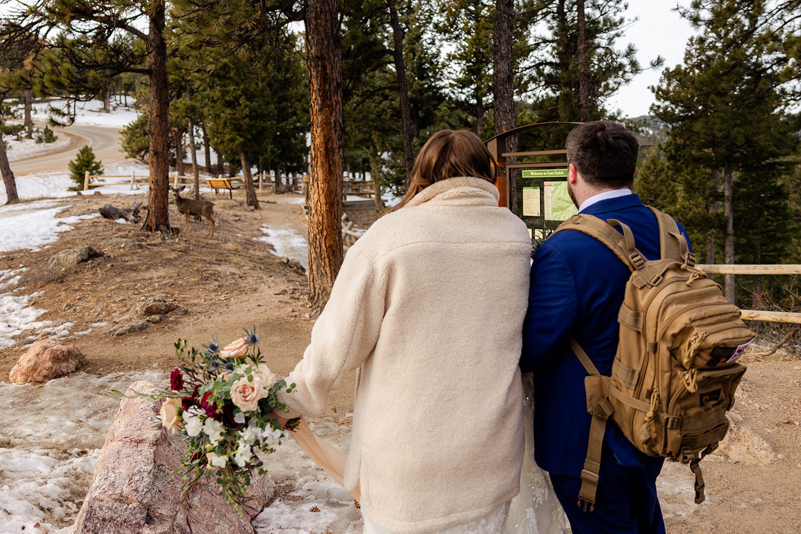 bride and groom walking back down the mountain after Lost Gulch elopement with  videography.