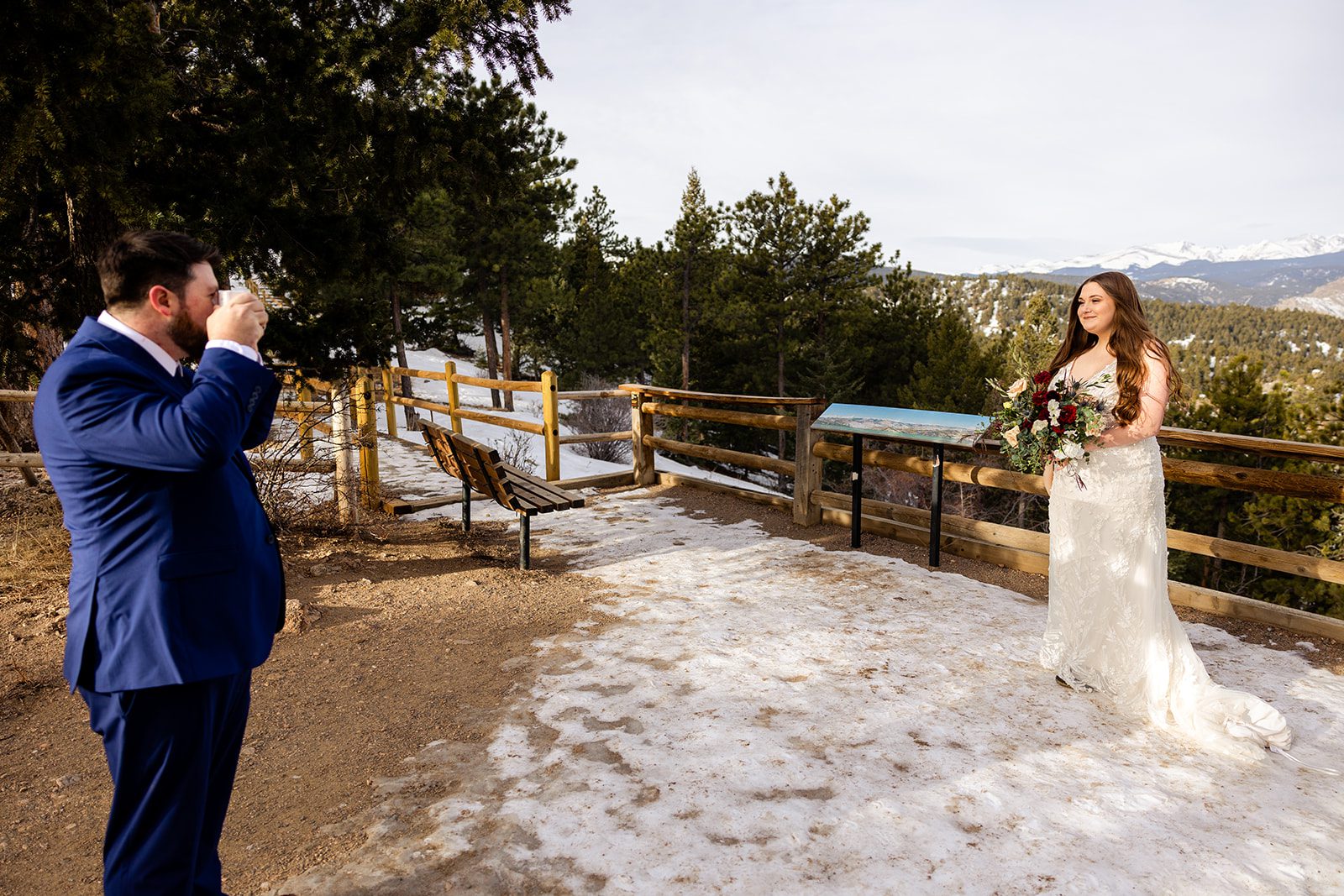 groom takes a photo his bride after their Lost Gulch elopement with  videography.