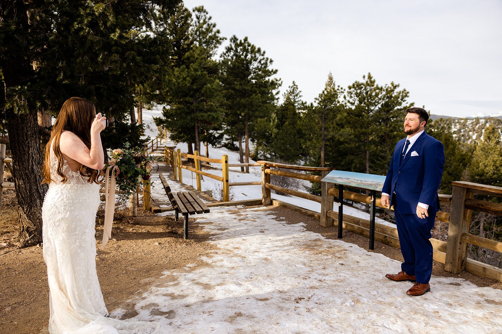 bride takes a photo of her groom after their Lost Gulch elopement with  videography.