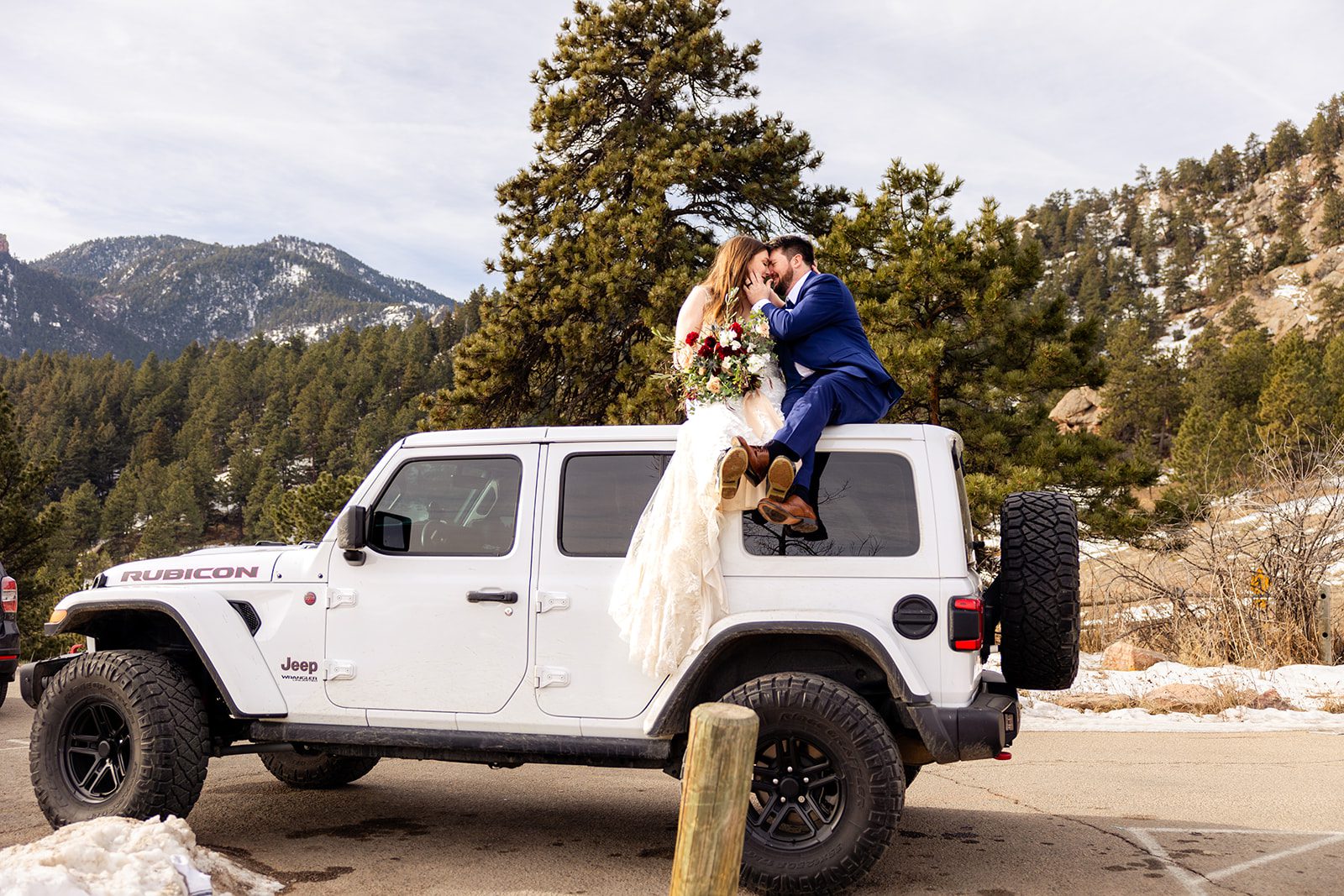 bride and groom sitting on top of the jeep at their Lost Gulch elopement with  videography.