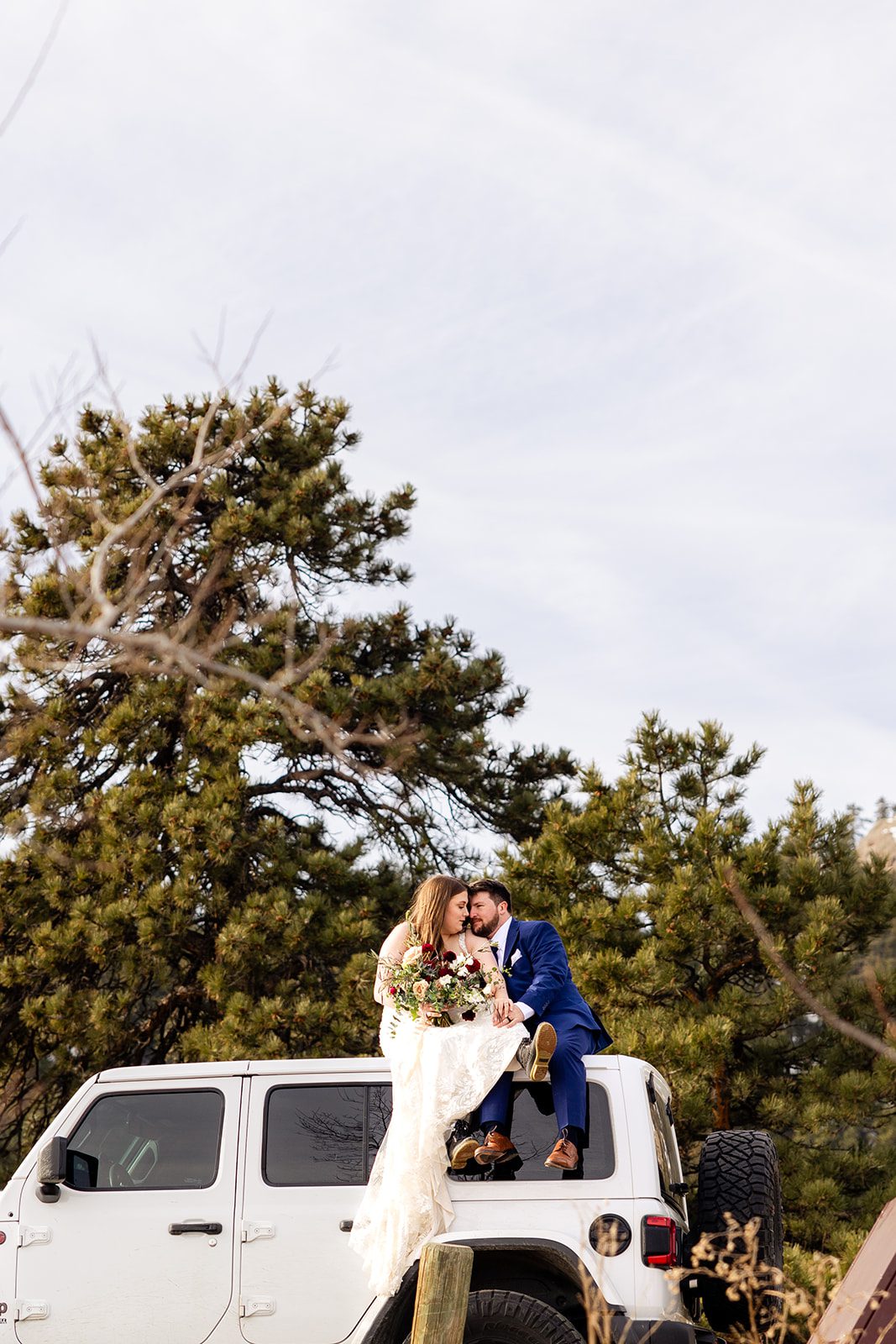 a far away shot of the bride and groom on top of the jeep at their Lost Gulch elopement with videography.