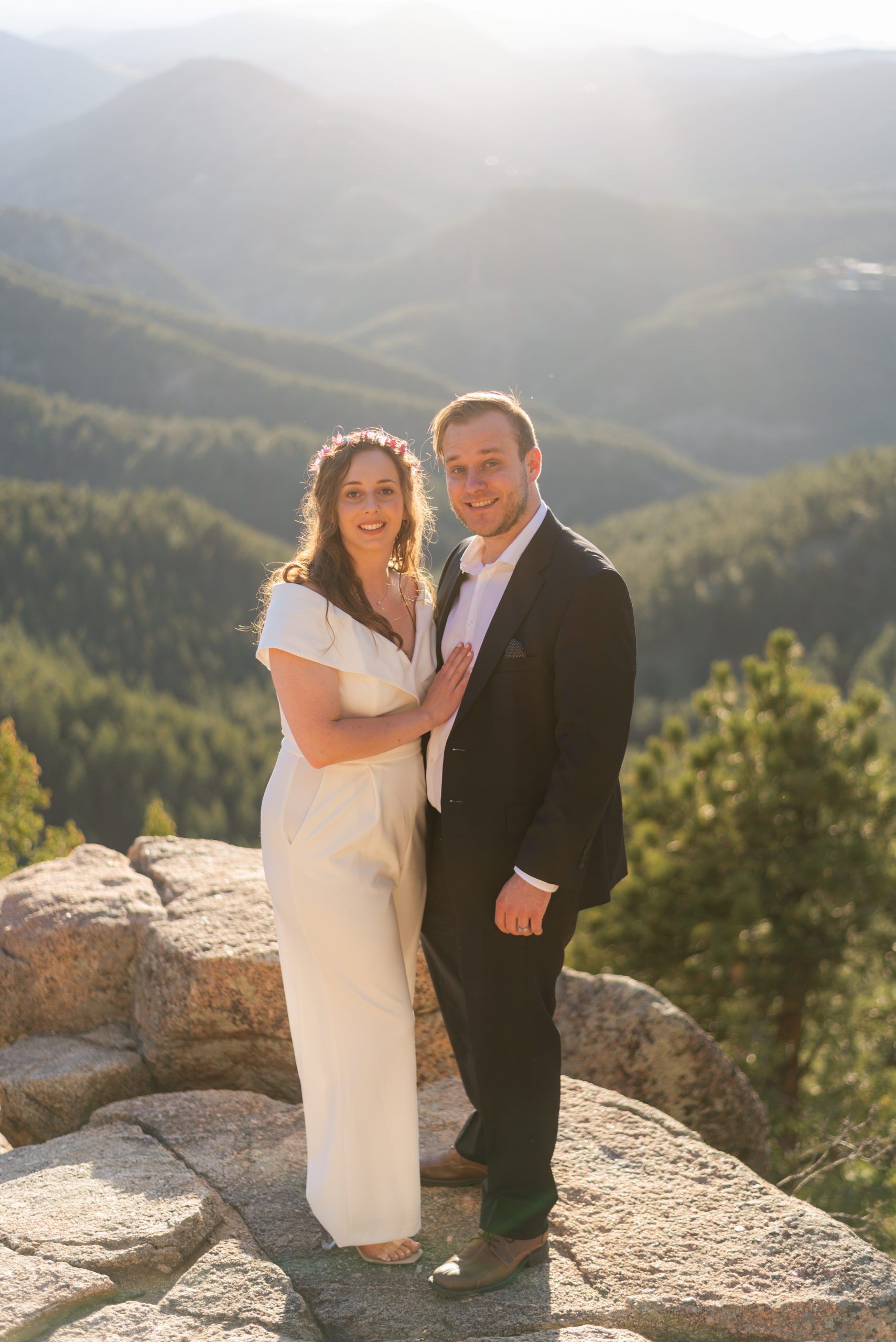 The bride and groom smile at the camera during their Boulder hiking elopement near realization point.