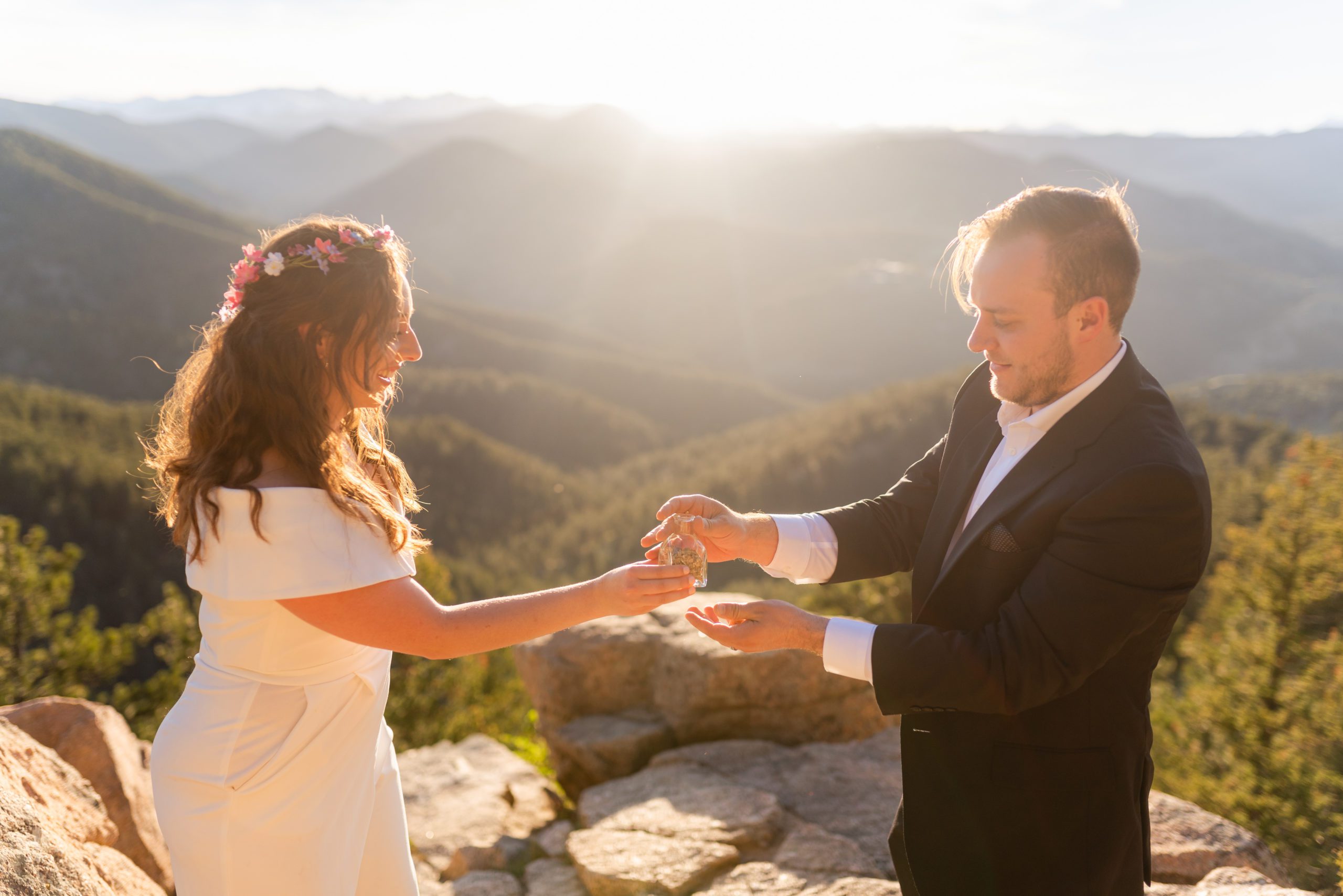 The Bride hands the keepsake jar to her groom on top of the overlook during their Boulder Hiking elopement near Realization point. 