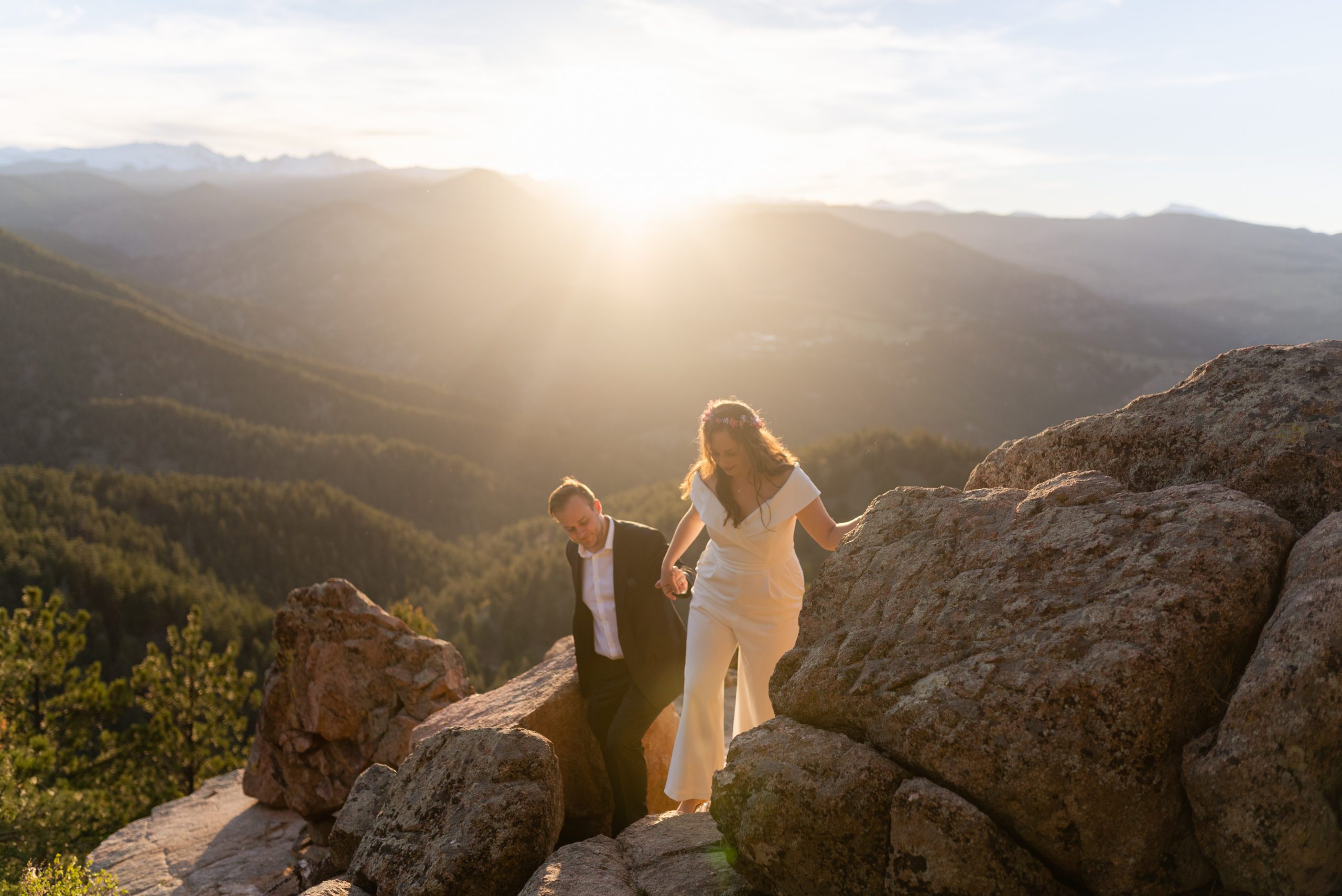 The bride and groom exploring the cliffside during their Boulder Hiking elopement near Realization point. 
