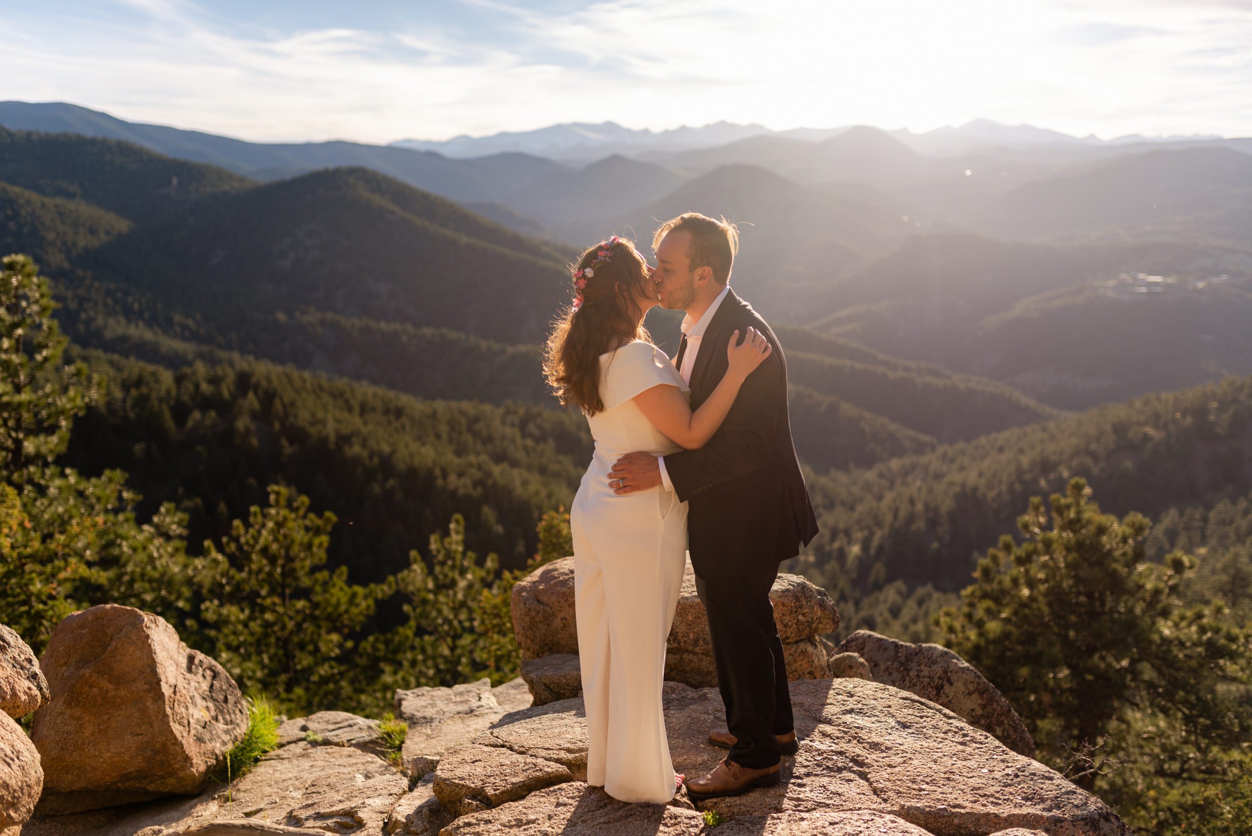 The bride and groom kiss sweetly at the top of the overlook during their Boulder hiking elopement near realization point.