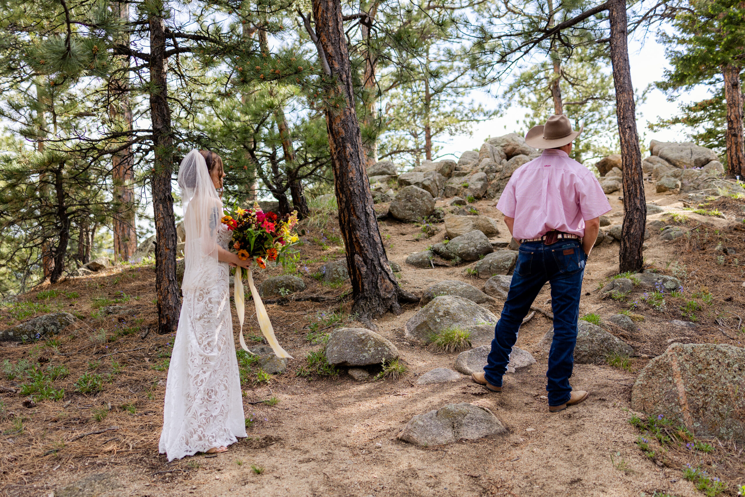 The bride stands behind her dad before their first look at the Sunrise Amphitheater for their Artist Point elopement. 