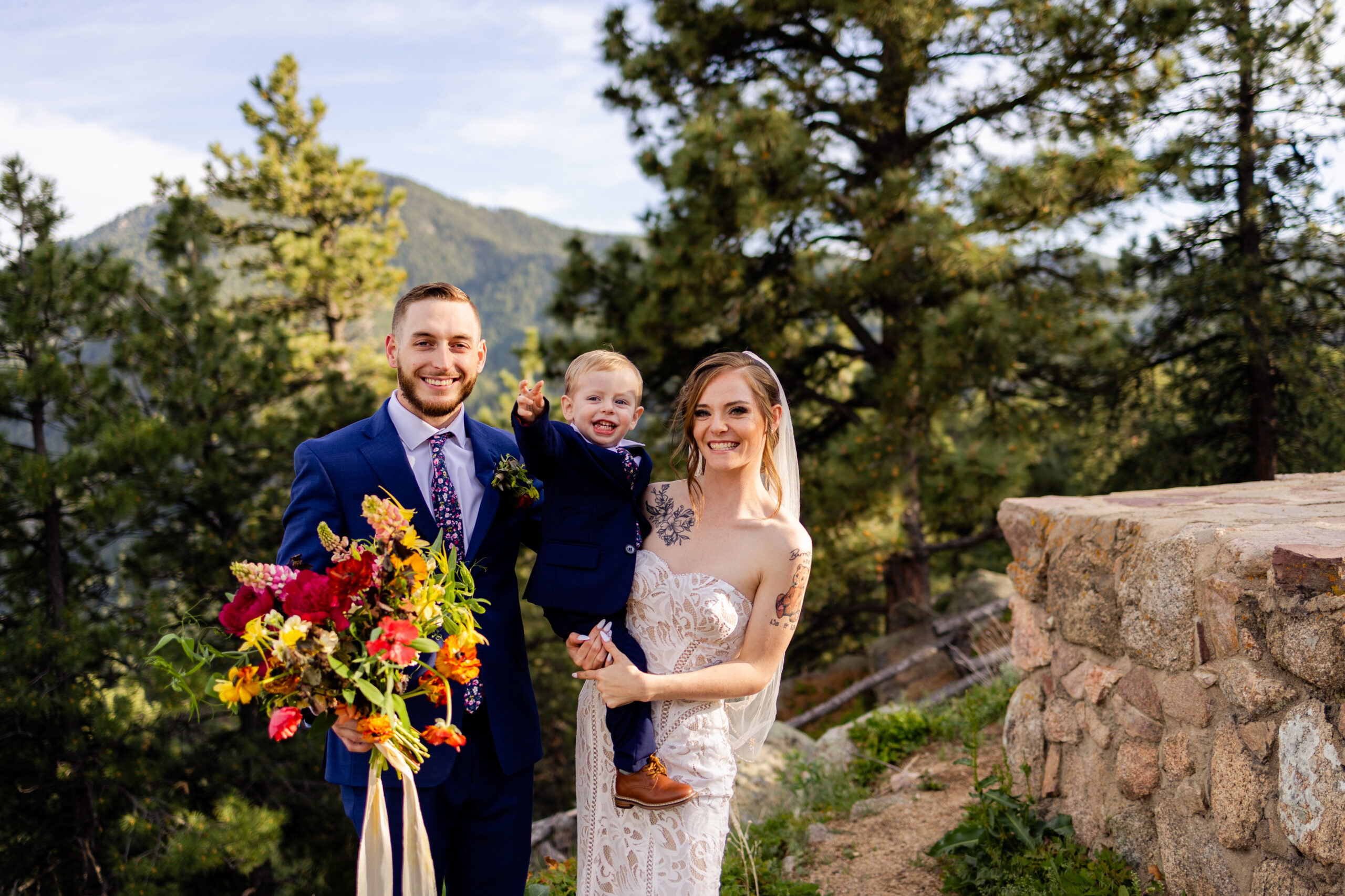 A family shot of the bride and groom with their son at Sunrise Amphitheater during their Elopement.