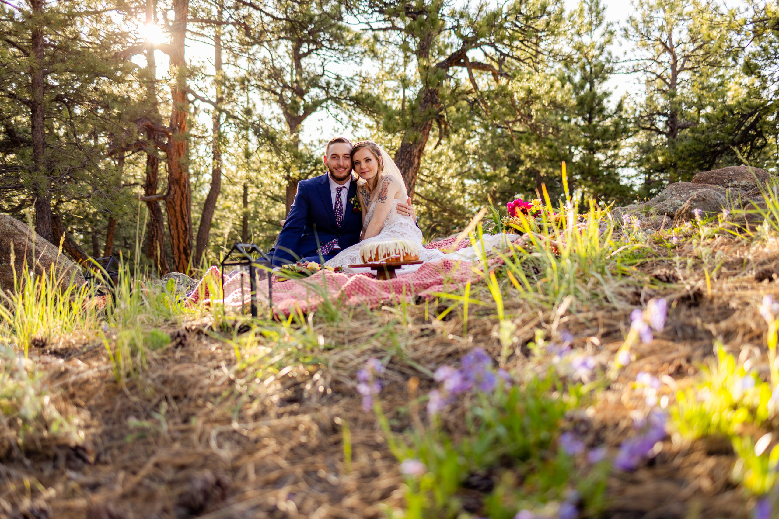 The bride and groom sitting on the blanket at their picnic at Artist Point after their Sunrise Amphitheater elopement ceremony. 