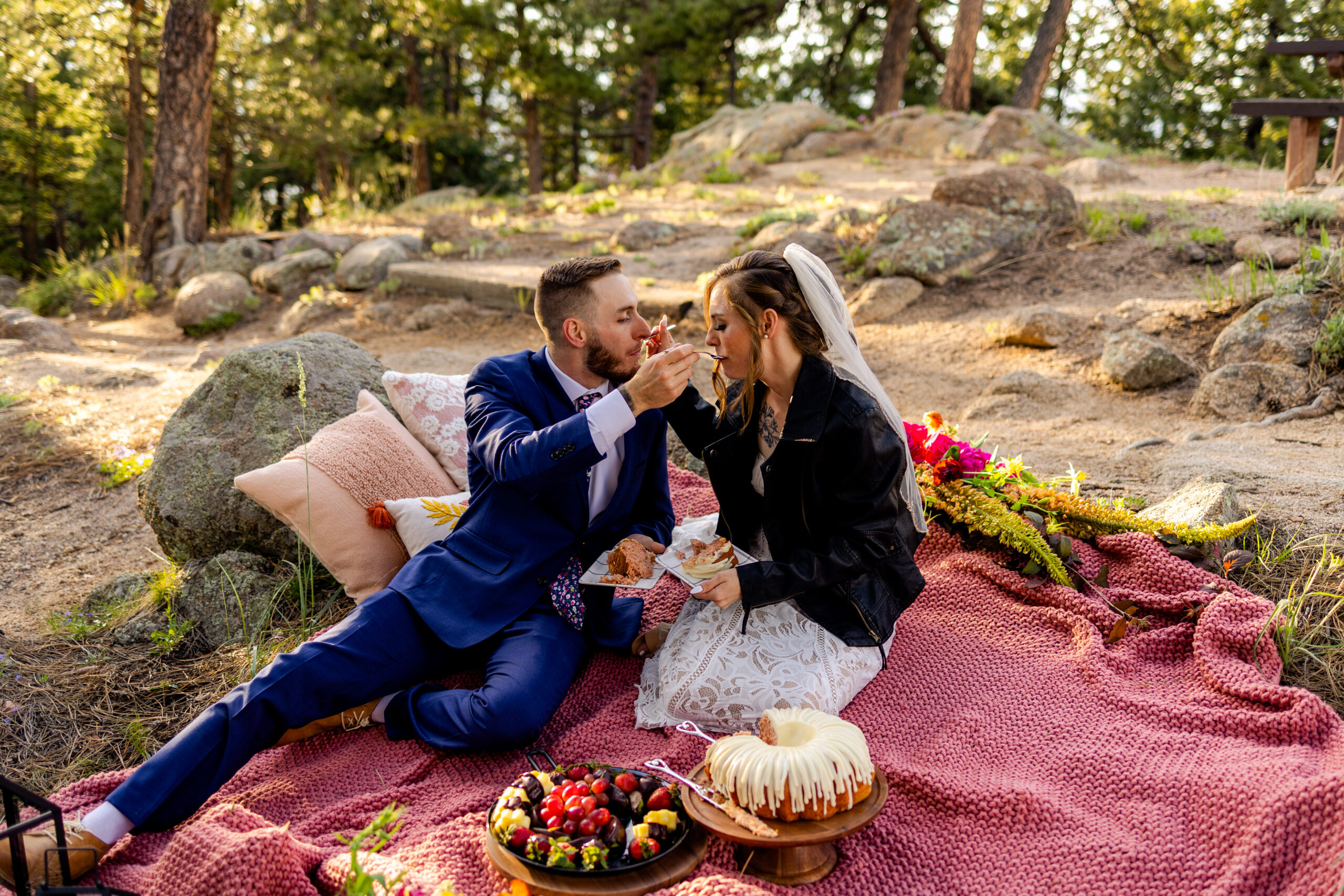 The bride and groom feeding each other cake at their picnic at Artist Point after their Sunrise Amphitheater elopement ceremony. 