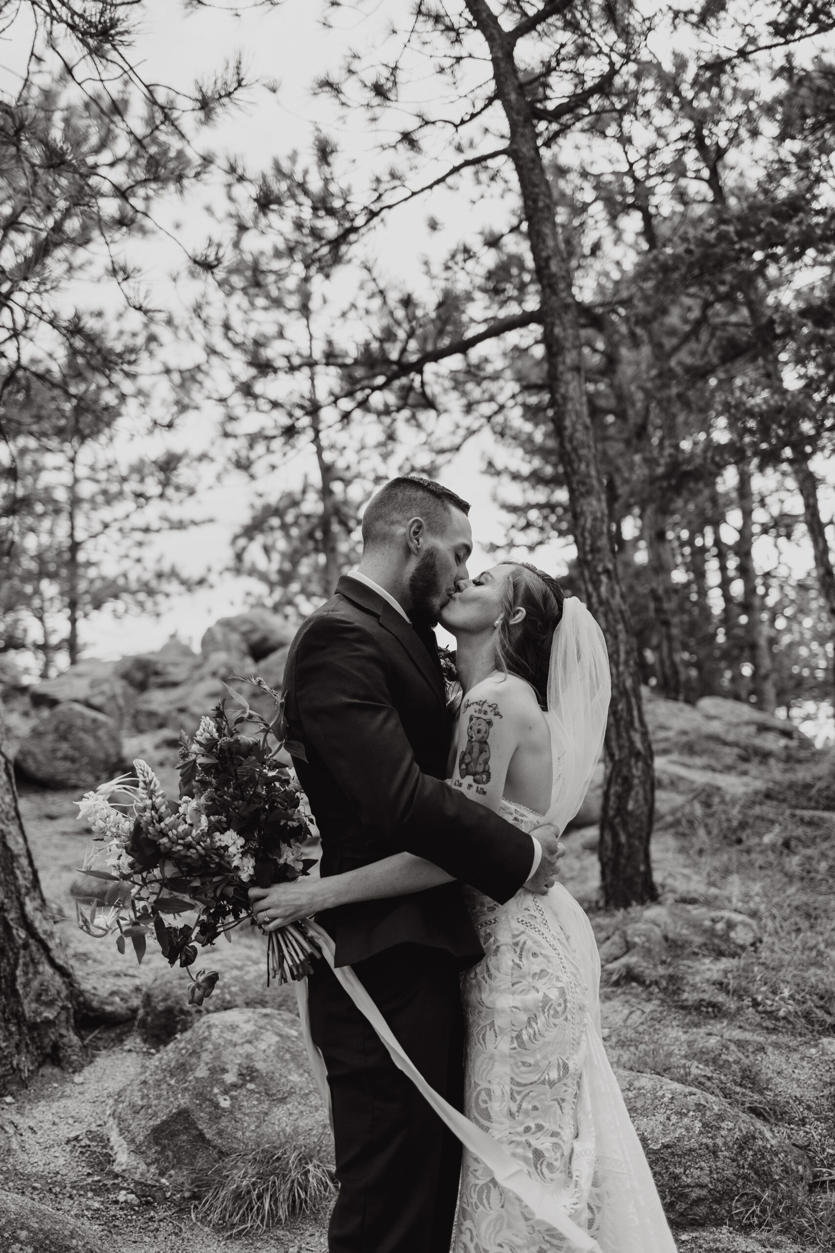 A black and white image of the bride and groom kissing before their ceremony at Sunrise Amphitheater.