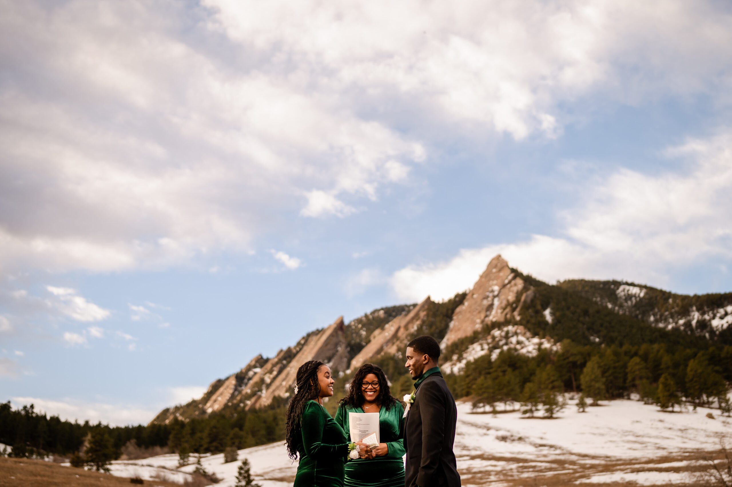 the gorgeous mountains in the background during an Chautauqua Trail elopement, the bride and groom in their foreground during their ceremony. 