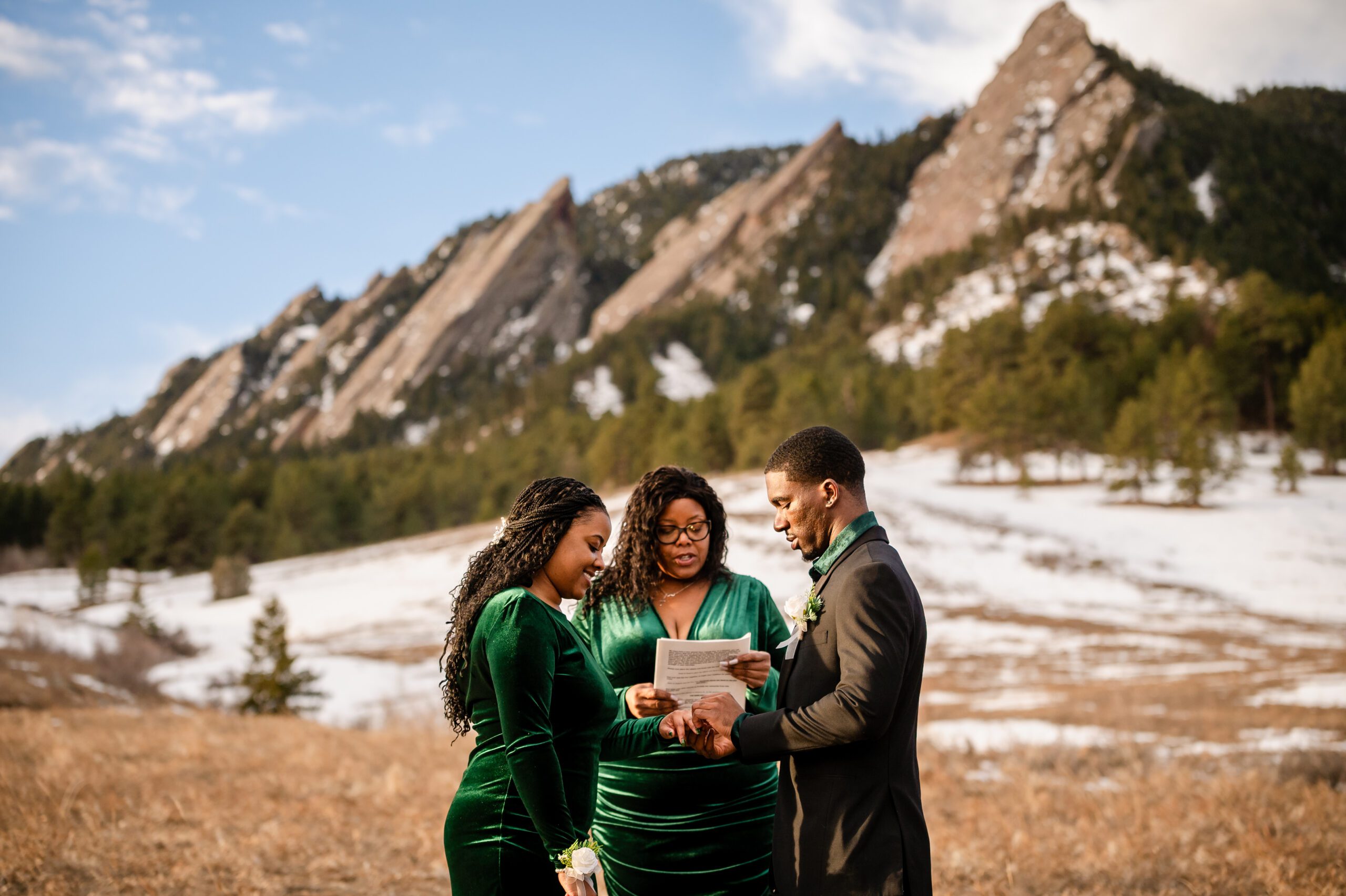 the groom places a ring on his brides finger during their Chautauqua Trail elopement. 