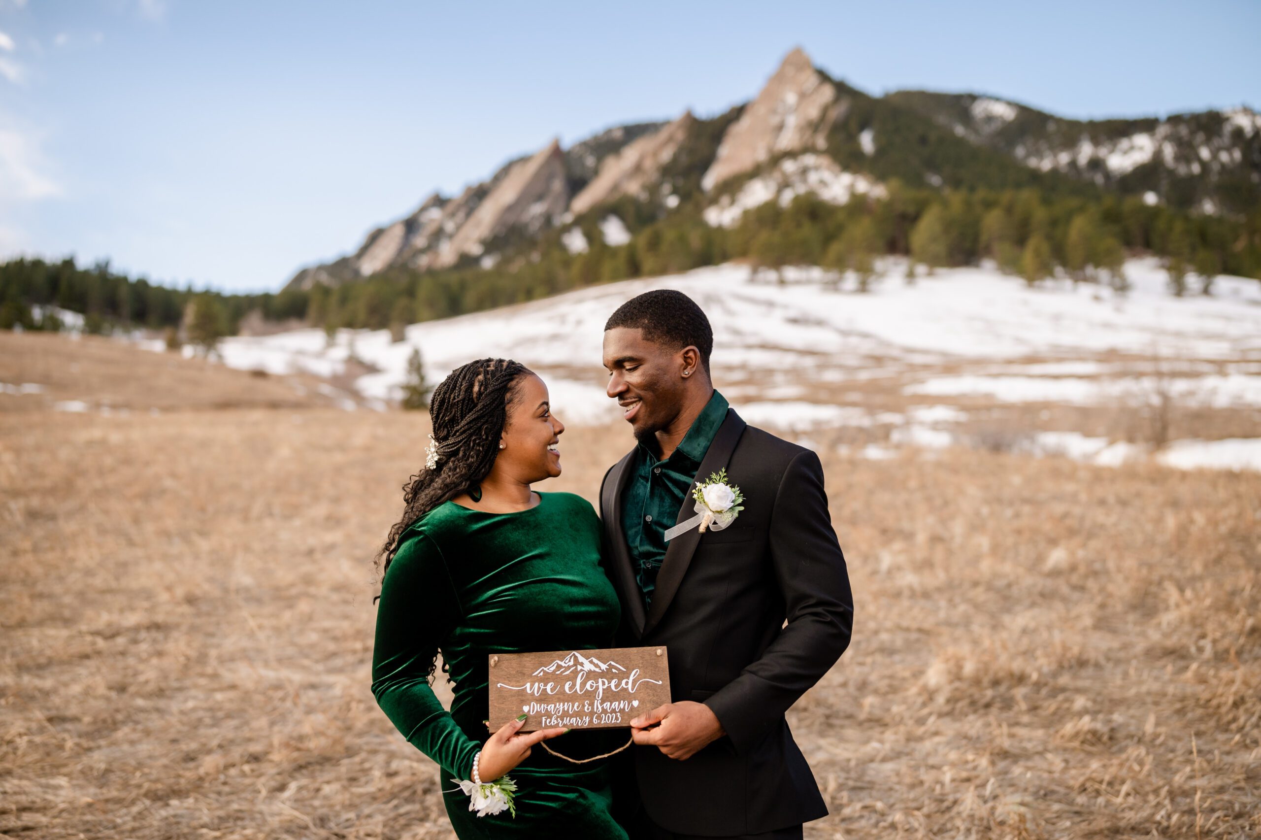 bride and groom hold a "we eloped" sign and look at each other after their Chautauqua Trail elopement.